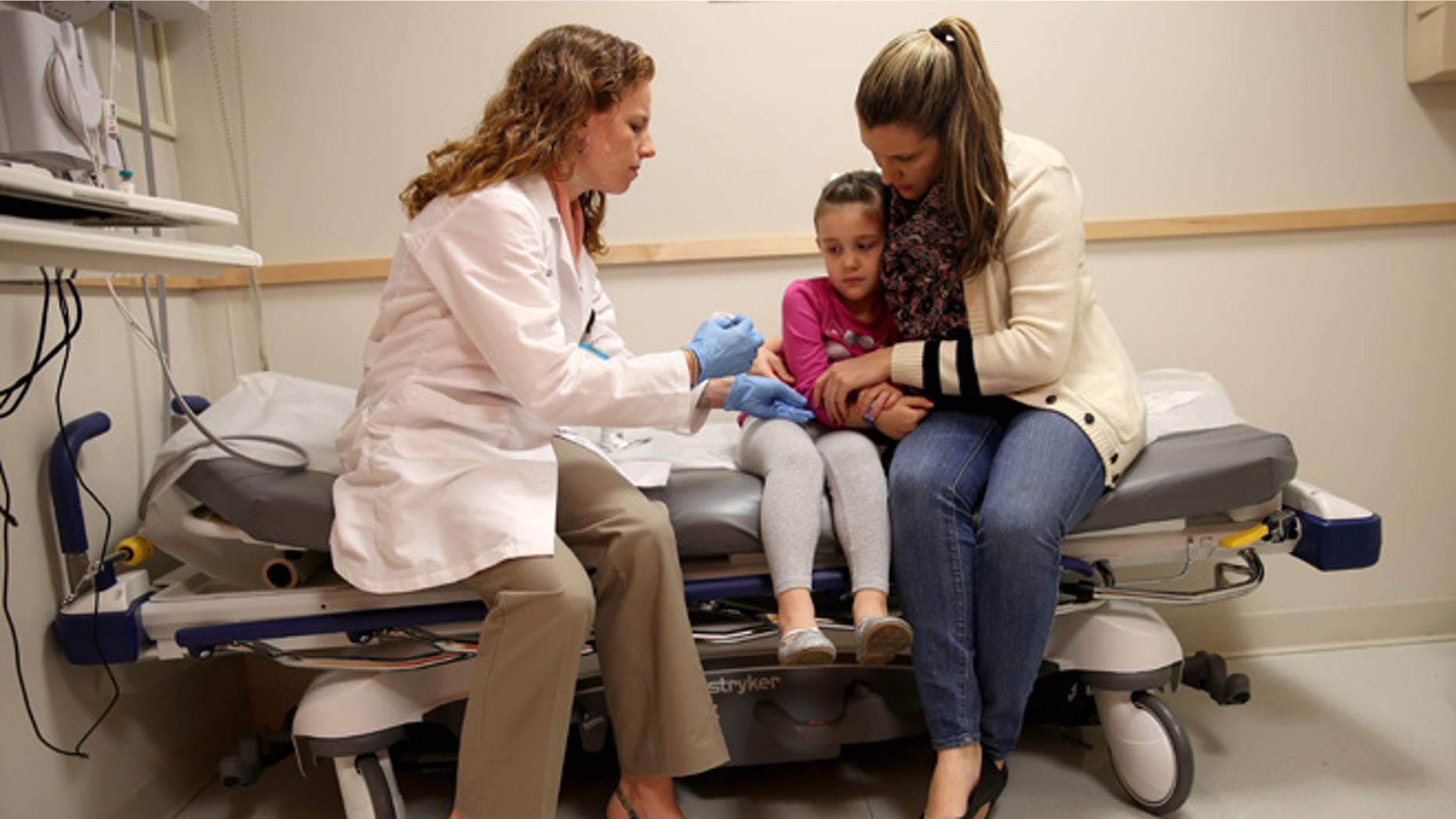 MIAMI, FL - JANUARY 28: Miami Children's Hospital pediatrician Dr. Amanda Porro, M.D prepares to administer a measles vaccination to Sophie Barquin,4, as her mother Gabrielle Barquin holds her during a visit to the Miami Children's Hospital on January 28, 2015 in Miami, Florida. A recent outbreak of measles has some doctors encouraging vaccination as the best way to prevent measles and its spread. (Photo by Joe Raedle/Getty Images)