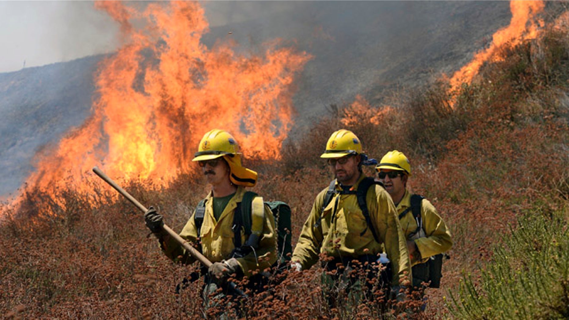 Firefighters battle the Bluecut Fire along Swarthout Canyon Road in the Cajon Pass, north of San Bernardino, Calif., Tuesday August 16, 2016. The blaze 60 miles east of Los Angeles has burned what appear to be several ranch outbuildings and forced evacuations in and around Lytle Creek. (Will Lester/The Sun via AP) MANDATORY CREDIT