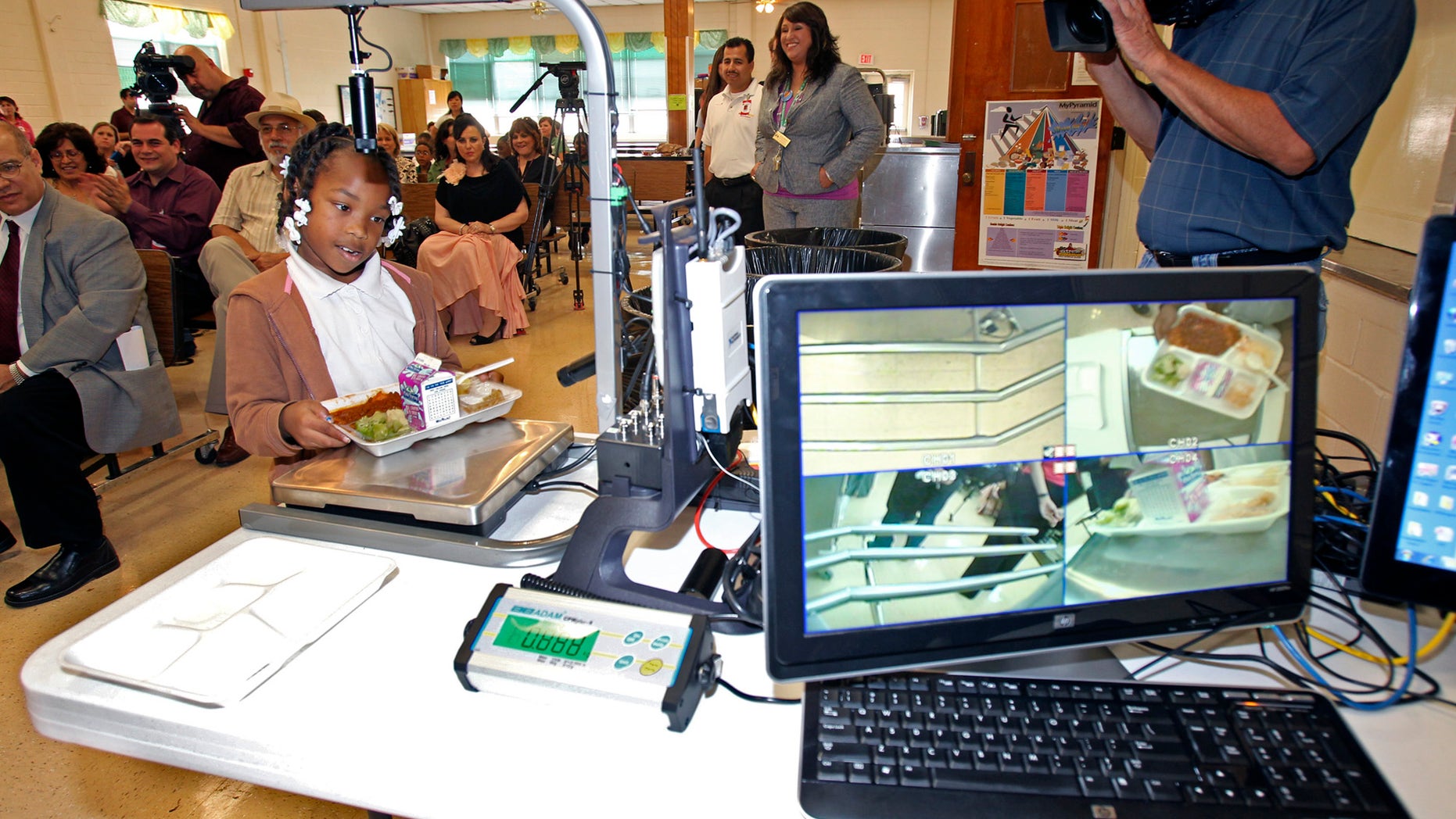 May 11: Third grader Alexis Brooks places her plate on the return tray as digital food analysis equipment is demonstrated at White Elementary in San Antonio.