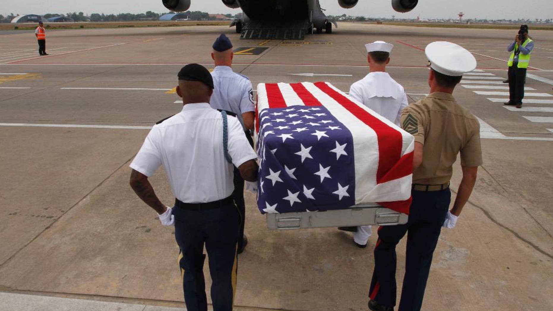 Four U.S. servicemen carry a coffin draped with the U.S. flag containing possible remains of a U.S. serviceman to a C-17 cargo plane during a repatriation ceremony at Phnom Penh International Airport, Cambodia, Wednesday, April 2, 2014. The possible remains of U.S. soldiers found in eastern Kampong Cham province were repatriated to Hawaii for testing. (AP Photo/Heng Sinith)