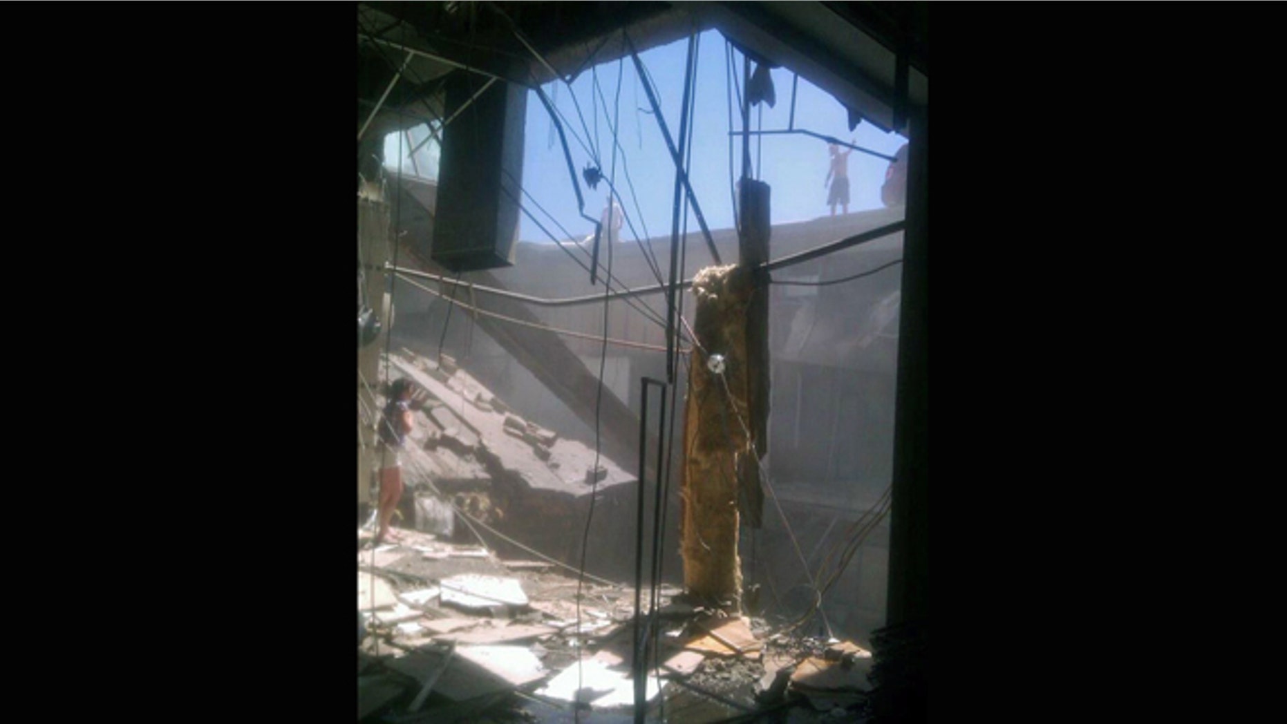June 23, 2012: A woman checks out the damage after a roof collapsed at the Algo Centre Mall in Elliot Lake, Ontario.