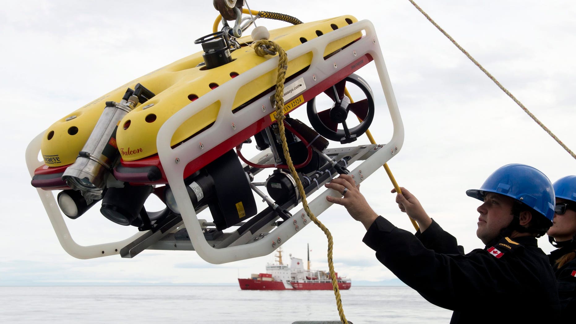 Aug. 24, 2014: A crew member of the HMCS Kingston loads an remote underwater vehicle part of the Victoria Strait Expedition, west of Pond Inlet on the Eclipse Sound.