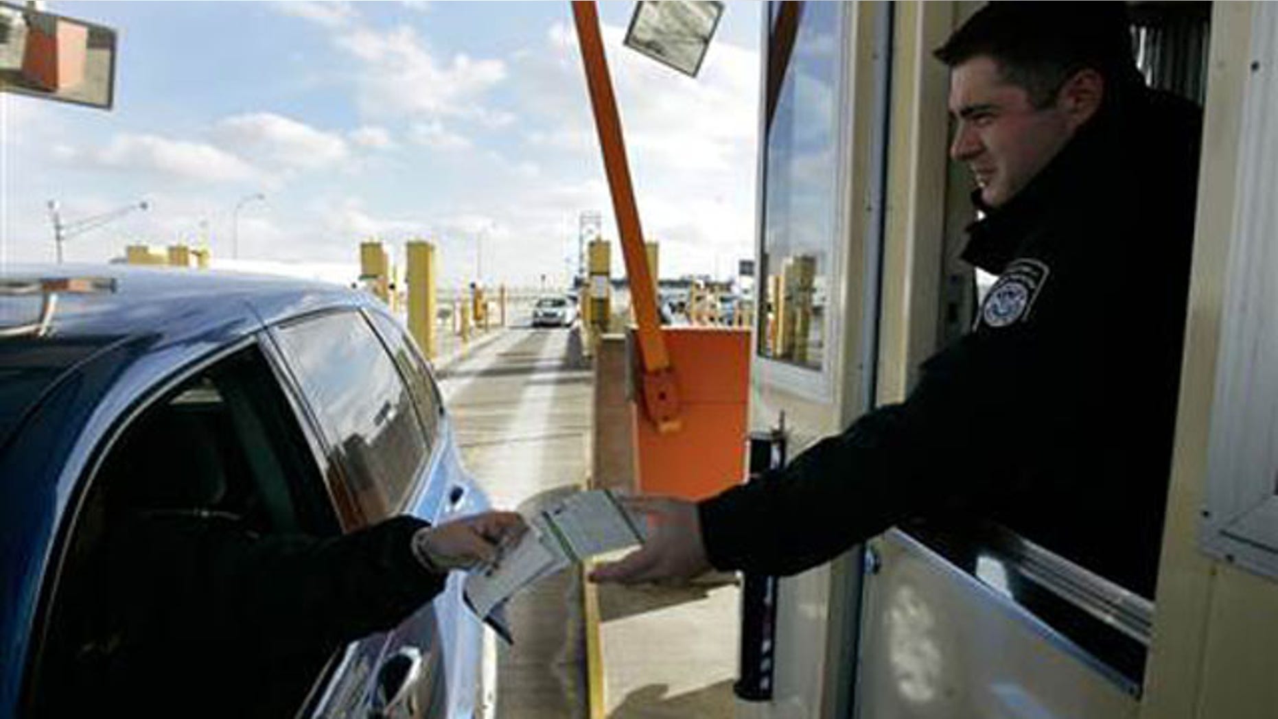 Jan. 31, 2008: A U.S. Customs officer hands back a Michigan drivers license and information pamphlet to a driver arriving from Canada at the Ambassador Bridge in Detroit.