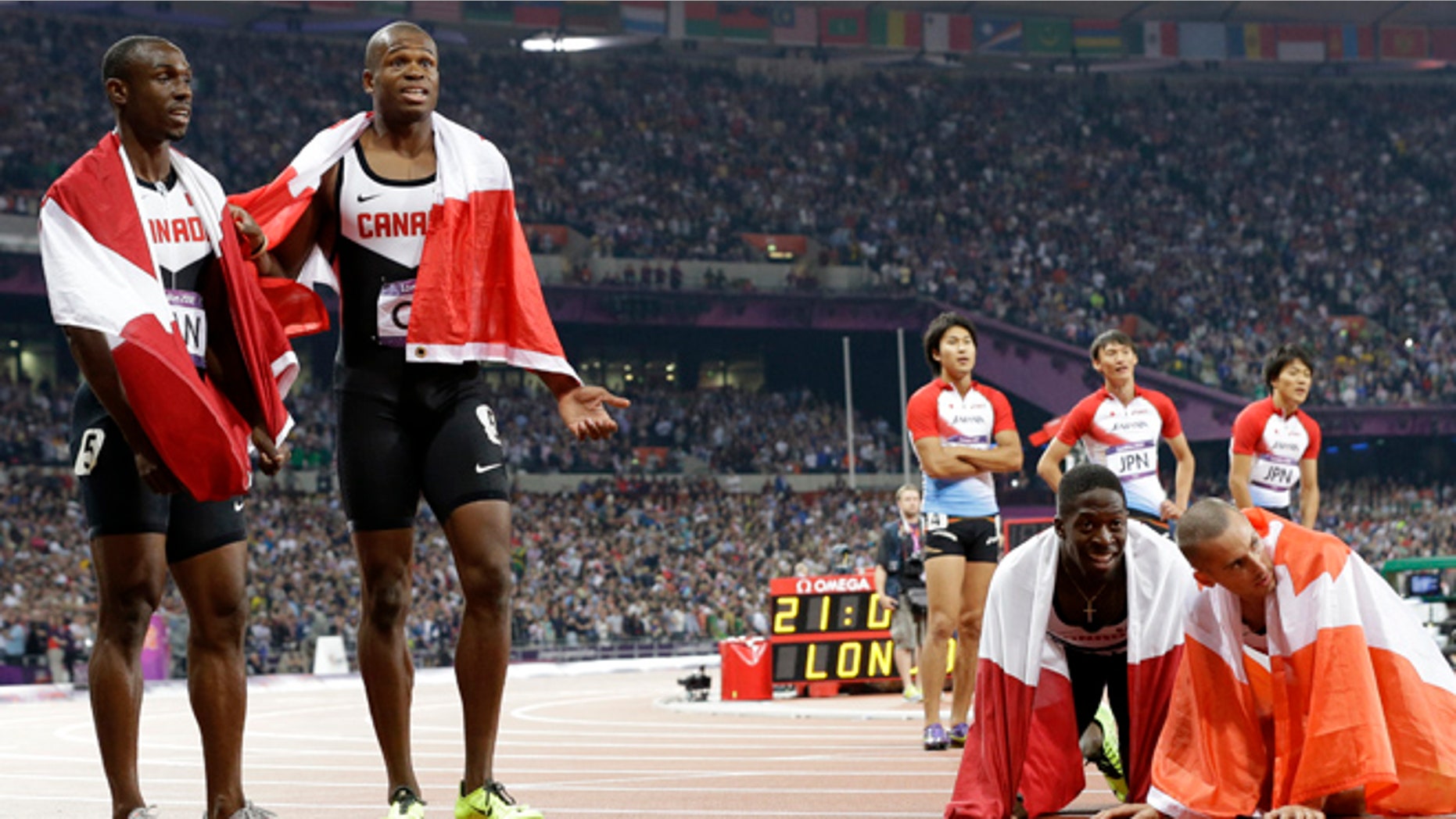Aug. 11, 2012: The men's relay teams from Canada and Japan react after competing in the men's 4 x 100-meter relay during the athletics in the Olympic Stadium at the 2012 Summer Olympics, London.
