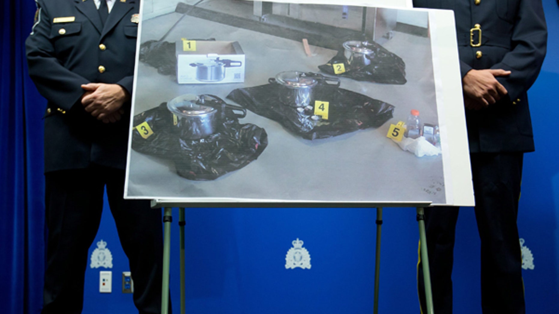 July 2, 2013: An evidence photo showing a set of pressure cookers is displayed during a news conference in Surrey, B.C.. Police have arrested a Canadian man and a woman and charged them as terrorist suspects for attempting to leave a suspicious package at British Columbia's provincial legislature on Canada Day.