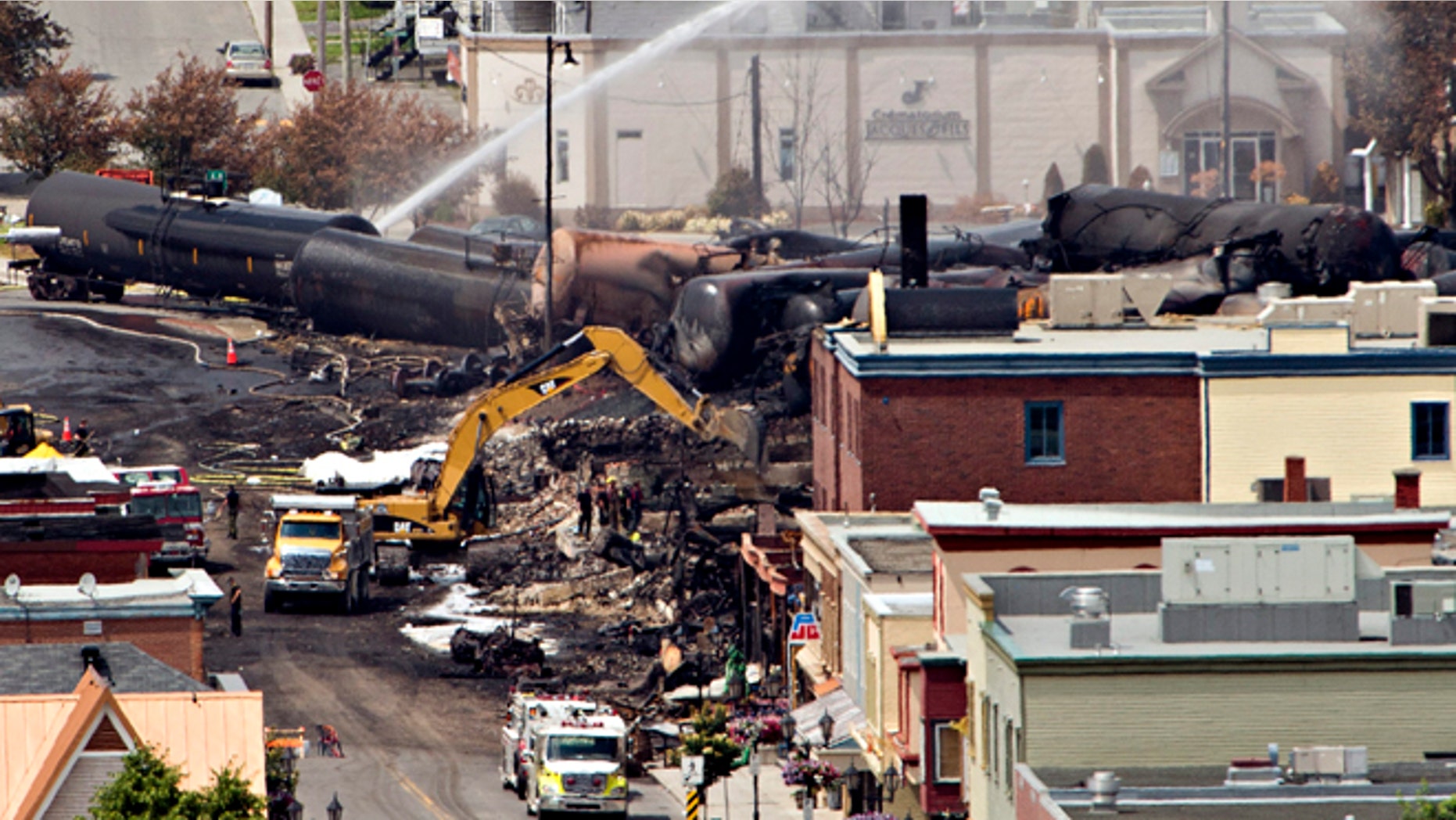 July 8, 2013: Searchers dig through the rubble for victims of the inferno in Lac-Megantic, Quebec as firefighter continue to hose down tanker cars to prevent explosions.