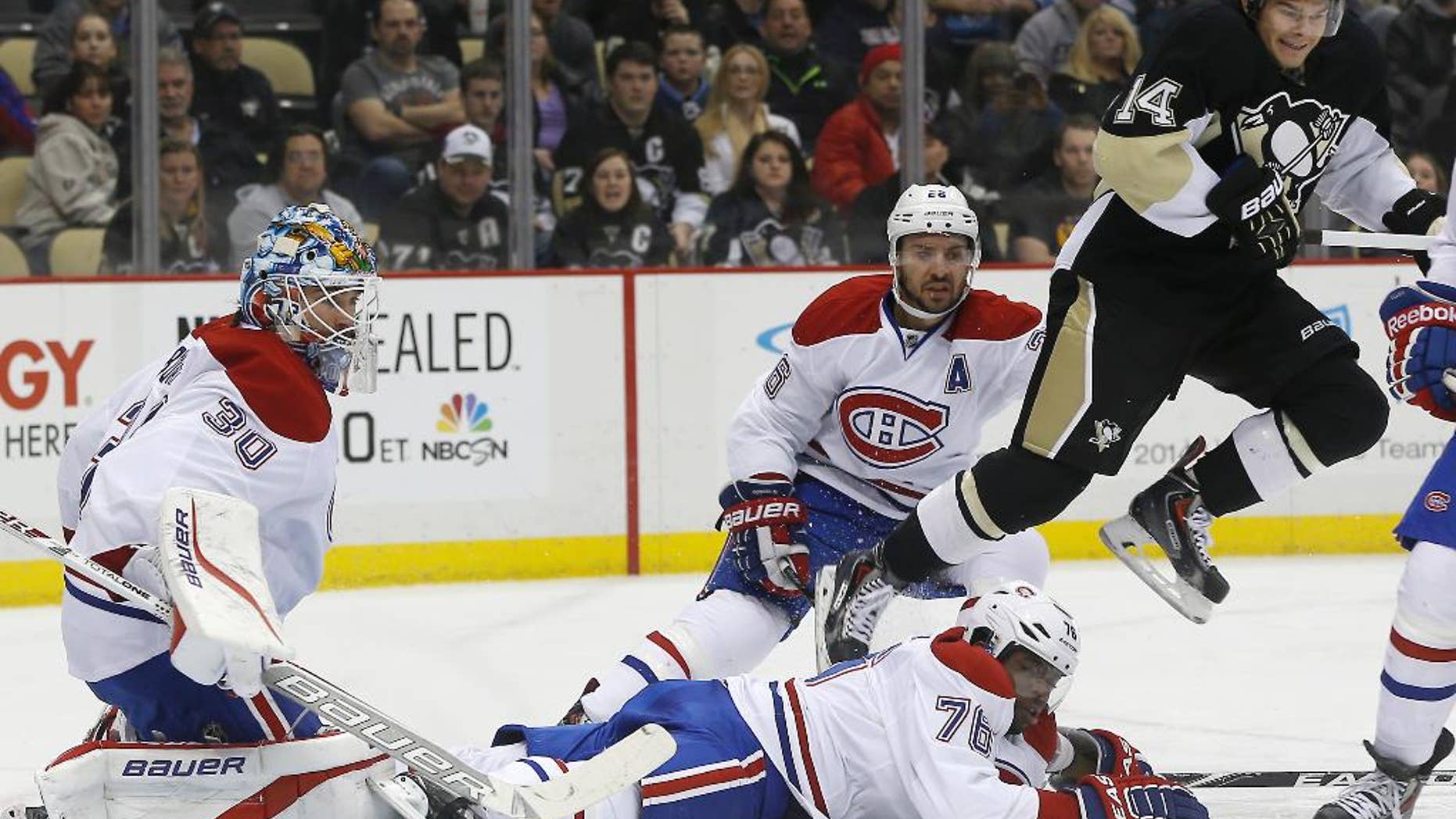 Pittsburgh Penguins' Chris Kunitz (14) hops over Montreal Canadiens' P.K. Subban (76) as he comes through the goal crease in front of goalie Peter Budaj (30), of Slovakia, during the second period of an NHL hockey game, Thursday, Feb. 27, 2014 in Pittsburgh. (AP Photo/Keith Srakocic)