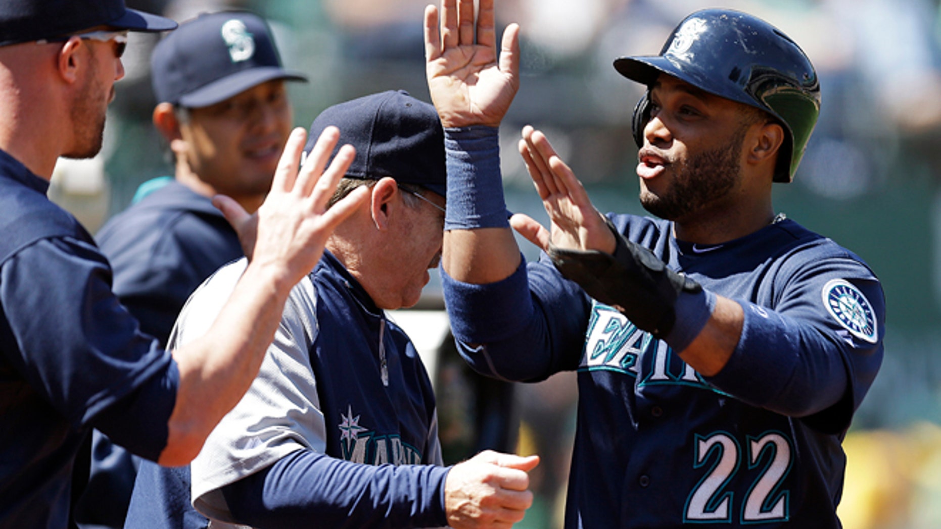 Seattle Mariners' Robinson Cano is congratulated after scoring against the Oakland Athletics in the third inning of a baseball game Sunday, April 6, 2014, in Oakland, Calif. Cano scored on a single by Justin Smoak. (AP Photo/Ben Margot)
