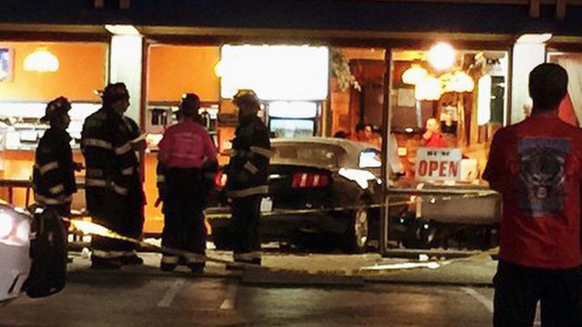 This Thursday, Oct. 23, 2014 photo provided by Leonard Rhone shows a car that plowed through a storefront in Dublin, Calif. Police say seven people were injured when a car crashed into the restaurant in a Northern California shopping center. A 56-year-old female driver had just pulled into a parking lot outside Taqueria Los Pericos in Dublin on Thursday night when she accidentally accelerated and plowed through the storefront. (AP Photo/Leonard Rhone)