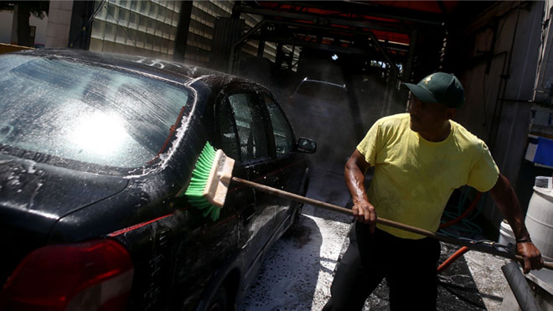 SAN MATEO, CA - JULY 29: A worker uses a brushe to clean a car at Ducky's Car Wash on July 29, 2015 in San Mateo, California. As California endures its fourth year of severe drought and state water officials have implemented mandatory water reductions, San Mateo County Health System officials are encouraging residents to have their cars washed by a local professional car wash instead of washing your car at home with a garden hose. Most professional car washes use recycled water and average about 20 gallons or less per wash versus up to 150 gallons for a home wash. (Photo by Justin Sullivan/Getty Images)