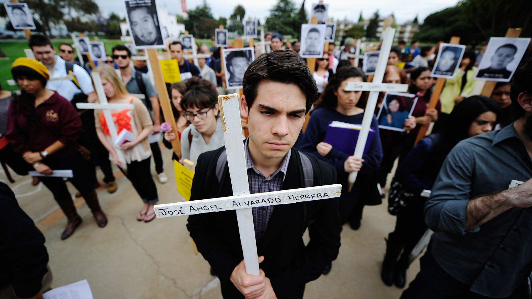 Loyola Marymount University student Michael Mardinkian takes part in a 50-cross procession on the university campus on April 25, 2012 in Los Angeles, California. The procession was led by Javier Sicilia, poet and leader of the Mexican anti-drug group Movement for Peace with Justice and Dignity, to raise awareness on the drug wars in Mexico and the United States to protest drug-related killings, with each cross representing 1,000 victims. (Photo by Kevork Djansezian/Getty Images)