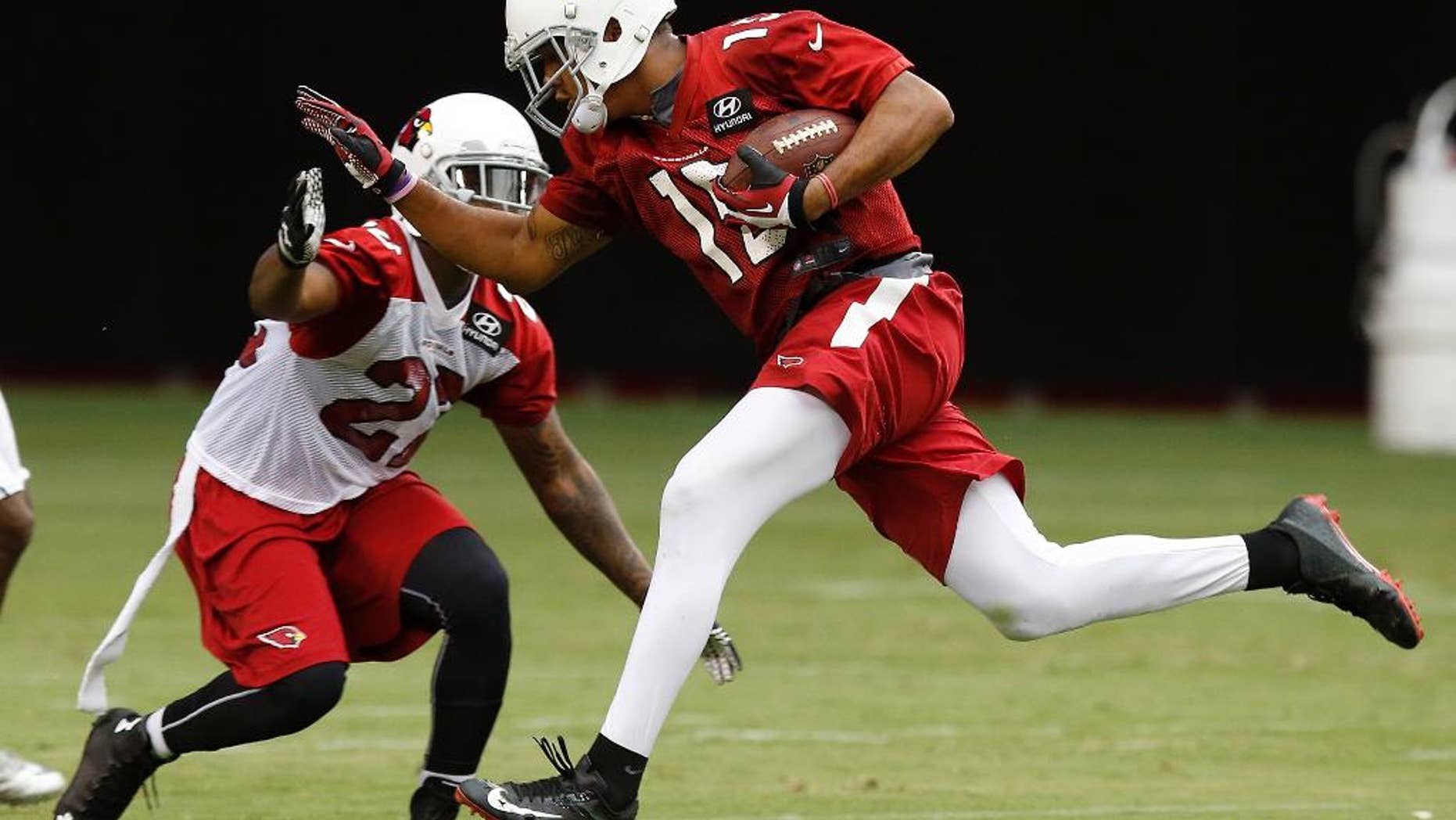 Arizona Cardinals' Michael Floyd, right, makes a catch in front of Tony Jefferson during the first day of NFL football training camp on Saturday, July 26, 2014, in Glendale, Ariz. (AP Photo/Ross D. Franklin)