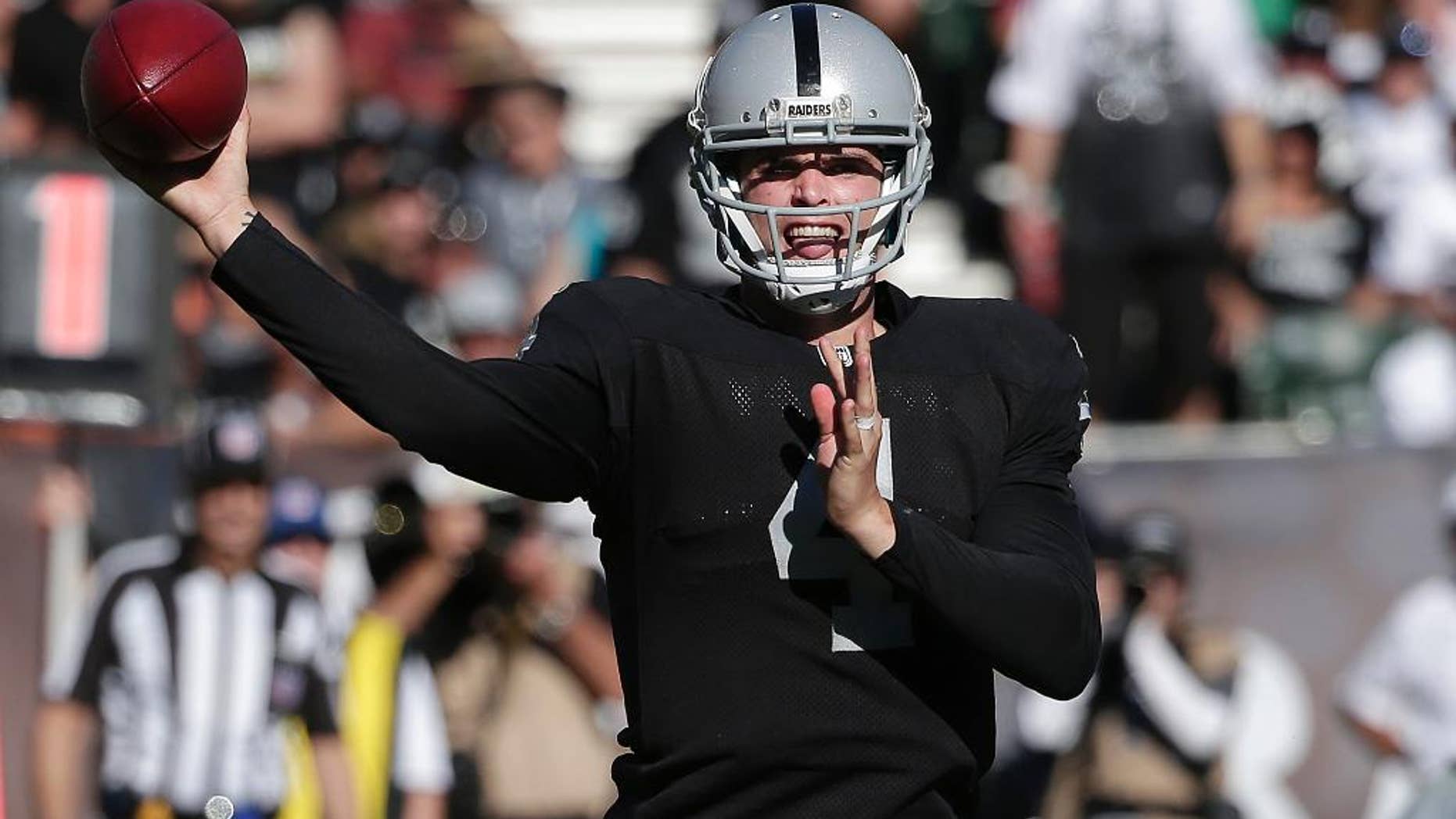 Oakland Raiders quarterback Derek Carr (4) passes against the Arizona Cardinals during the second half of an NFL football game in Oakland, Calif., Sunday, Oct. 19, 2014. The Cardinals won 24-13. (AP Photo/Marcio Jose Sanchez)