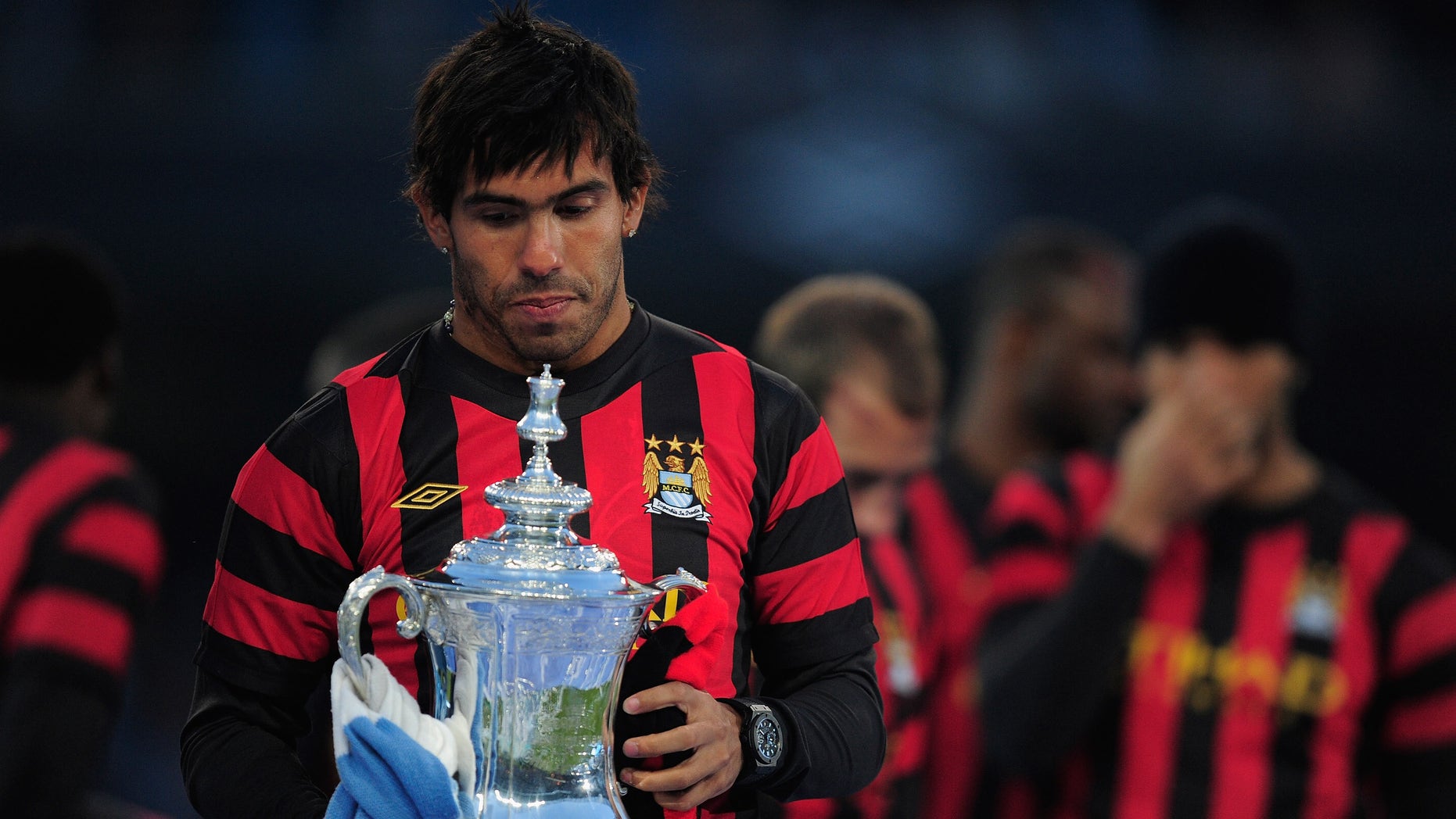 MANCHESTER, ENGLAND - MAY 23: Carlos Tevez of Manchester City lifts the FA Cup tduring the Manchester City FA Cup Winners Parade at the City of Manchester stadium on May 23, 2011 in Manchester, United Kingdom. (Photo by Jamie McDonald/Getty Images)