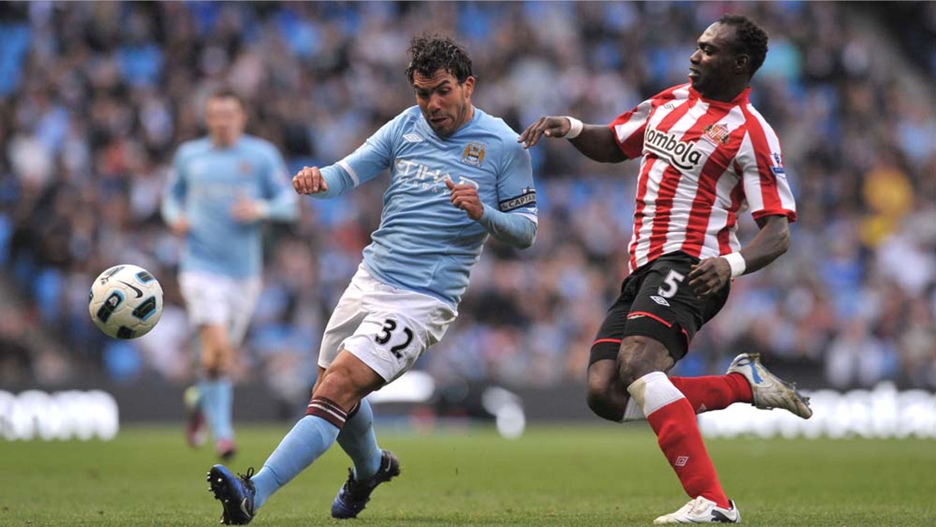 Manchester City's Carlos Tevez, left, keeps the ball from Sunderland's John Mensah during their English Premier League soccer match at The City of Manchester Stadium, Manchester, England, Sunday April 3, 2011. (AP Photo/Jon Super) NO INTERNET/MOBILE USAGE WITHOUT FOOTBALL ASSOCIATION PREMIER LEAGUE(FAPL)LICENCE. EMAIL info@football-dataco.com FOR DETAILS.
