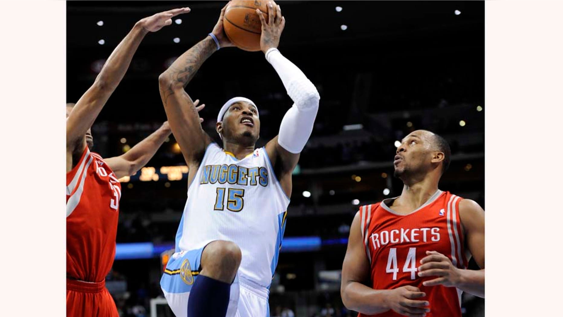 Denver Nuggets forward Carmelo Anthony (15) goes up for a shot against Houston Rockets center Chuck Hayes (44) during the fourth quarter of an NBA basketball game on Monday, Feb. 7, 2011, in Denver. Houston beat Denver 108-103. (AP Photo/Jack Dempsey)
