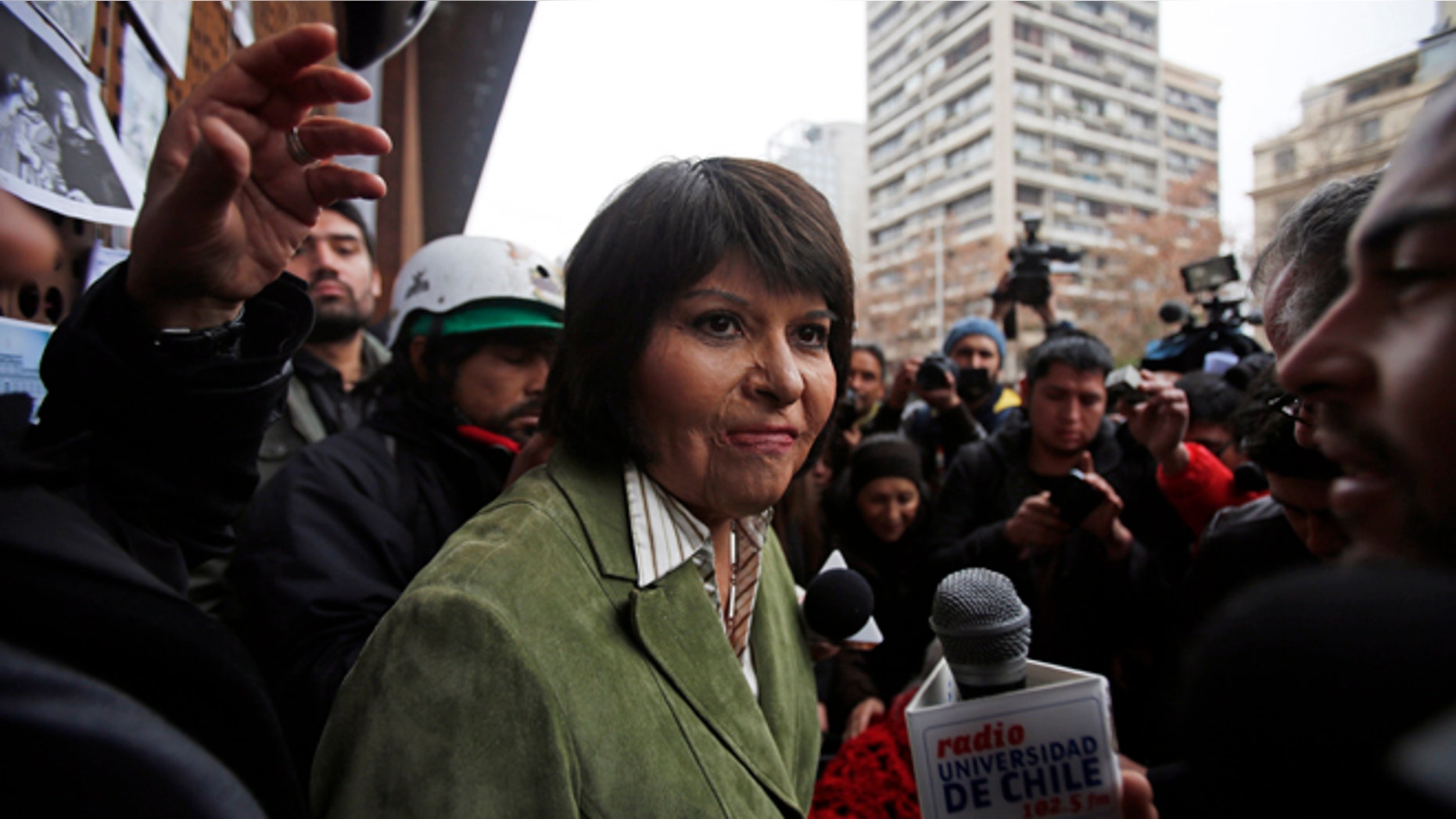 Carmen Quintana attends a tribute for slain photographer Rodrigo Rojas, outside the Gabriela Mistral museum, in Santiago, Chile, Tuesday, July 28, 2015. During a street demonstration on July 2, 1986, soldiers doused Rojas and then 18-year-old Quintana with gasoline and set them ablaze. Rojas died four days later. Quintana survived and underwent lengthy treatment for severe burns at a Canadian hospital. Her scarred face later became a symbol of the atrocities committed by Pinochet's dictatorship. A Chilean judge last week charged seven former members of the military in the burning death of Rojas, and four other ex-soldiers were being questioned on Monday. (AP Photo/Luis Hidalgo)