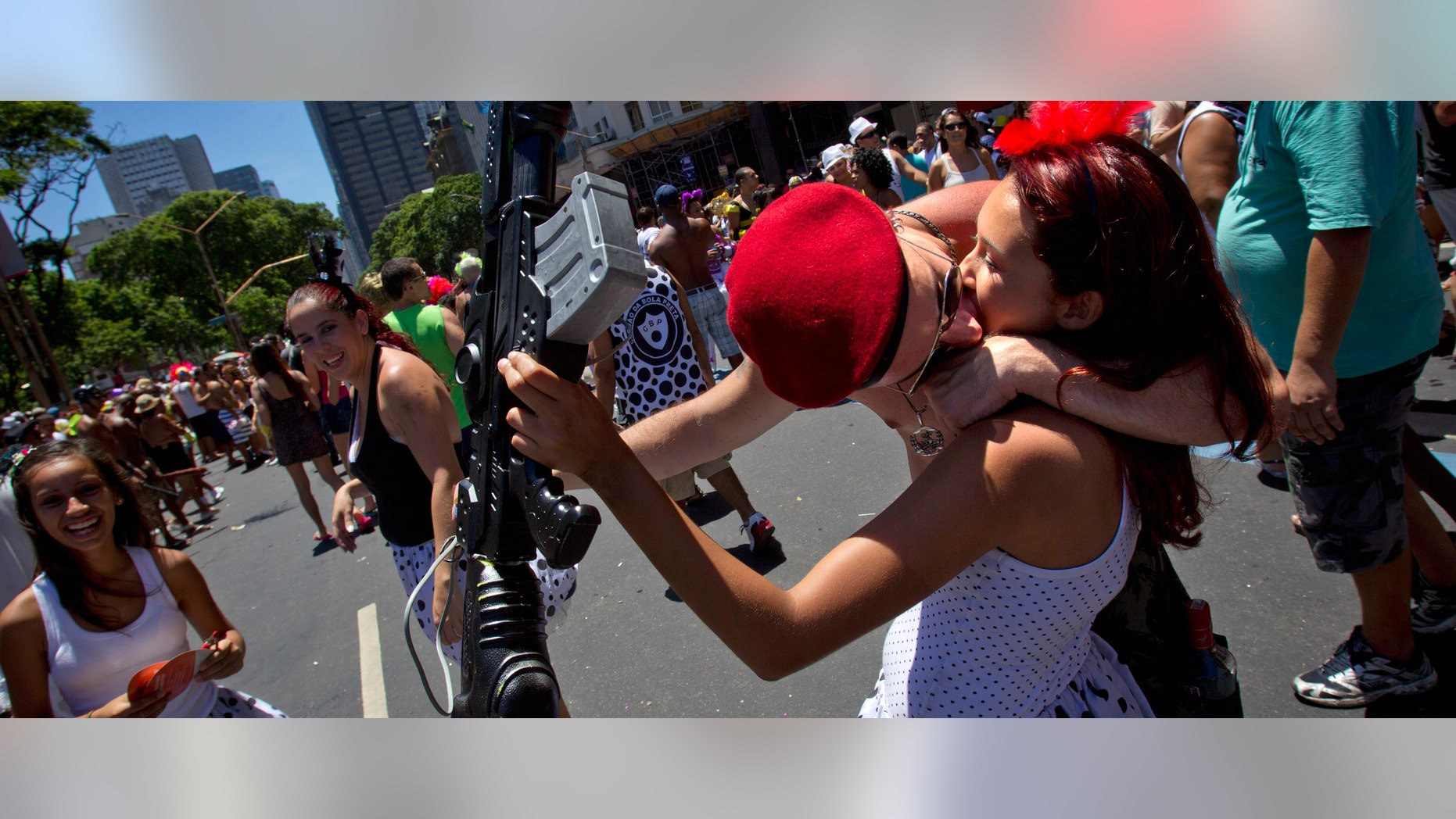 Revelers kiss during the Cordao da Bola Preta carnival parade in downtown Rio de Janeiro, Brazil, Saturday Feb. 18, 2012. Thousands of people gathered Saturday to march with one of Rio's most popular and traditional blocos or parade groups, created in the early 1900's and believed to be named for a beautiful woman in a black and white polka-dress. (AP Photo/Victor R. Caivano)