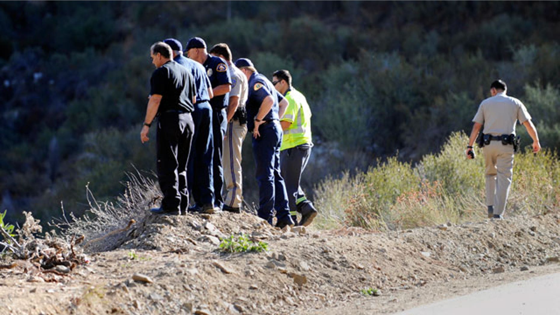 California Highway patrol officers investigate the scene of two cars that were recovered at the bottom of a remote mountain in Castaic, Calif., Friday, Sept. 30, 2011 .