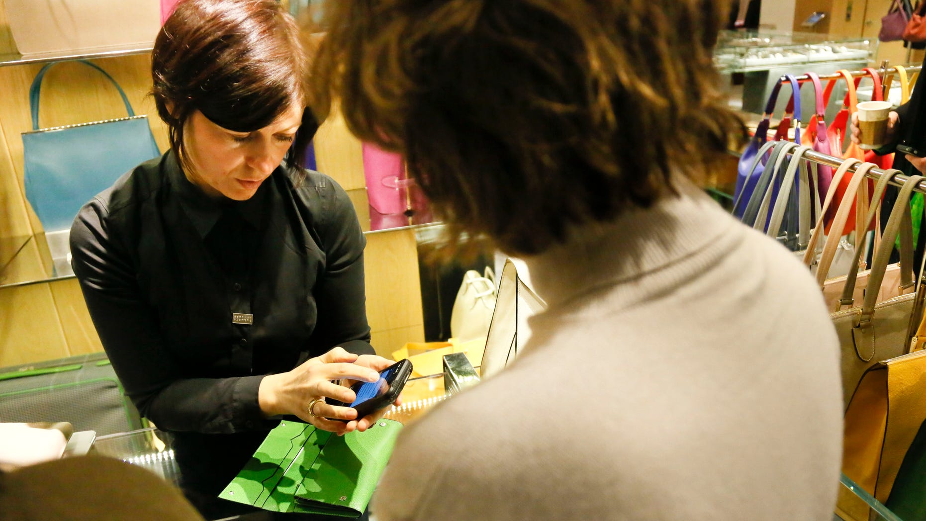 Feb. 15, 2013: A sales staff member at Barney's New York uses an iPod Touch to help a customer make a purchase, in New York.