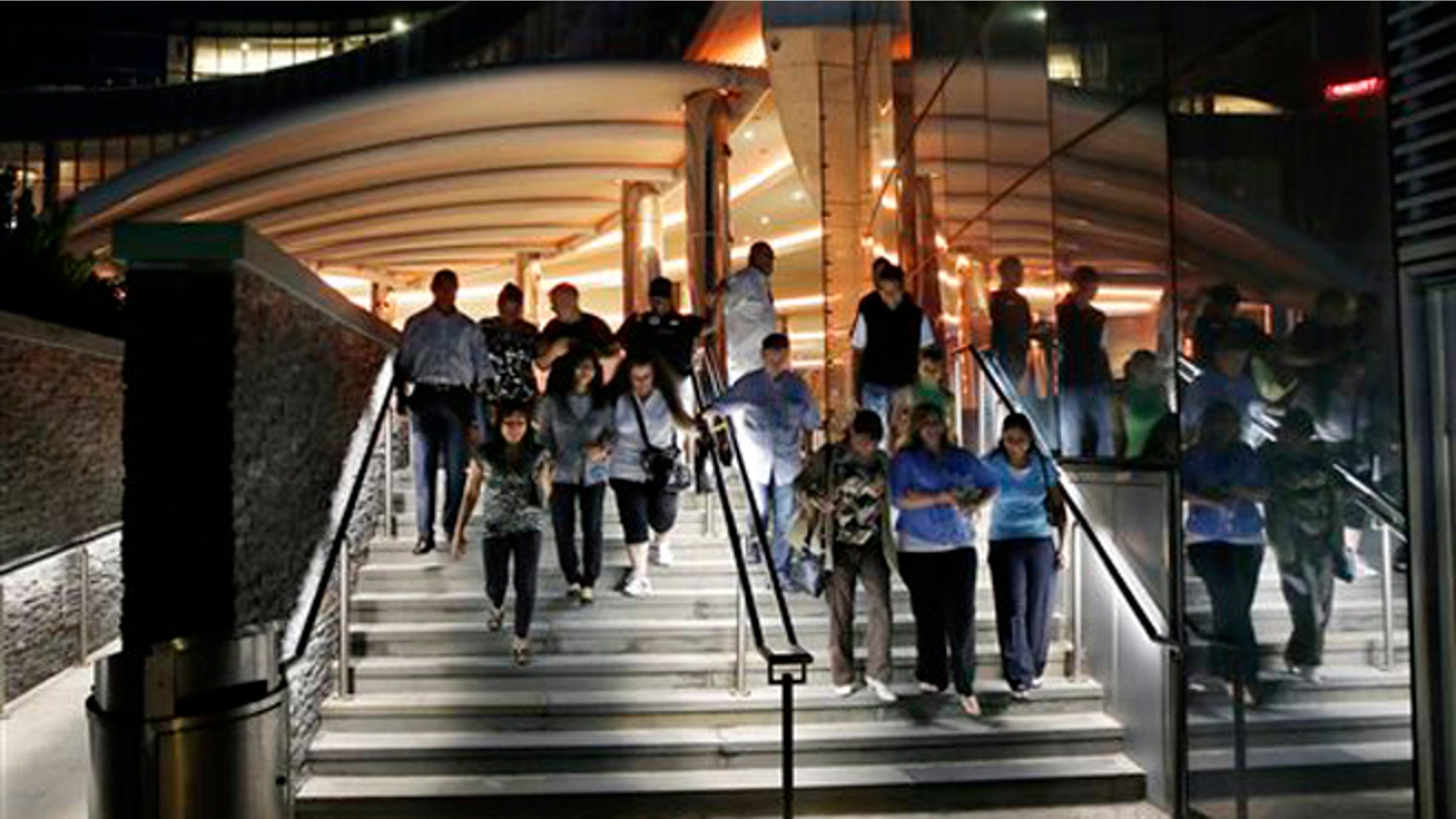 Casino workers and customers walk out of The Revel Hotel Casino together early in the morning Tuesday, Sept. 2, 2014, in Atlantic City, N.J. The casino section of the Revel closed at 6:30 a.m.Tuesday. Revel is shutting down a little over two years after opening with high hopes of revitalizing Atlantic City's struggling gambling market. (AP Photo/Mel Evans)