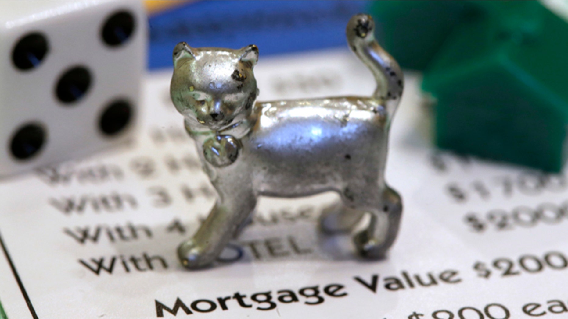 Feb. 5: The newest Monopoly token, a cat, rests on a Boardwalk deed next to a die and houses at Hasbro Inc. headquarters, in Pawtucket, R.I.
