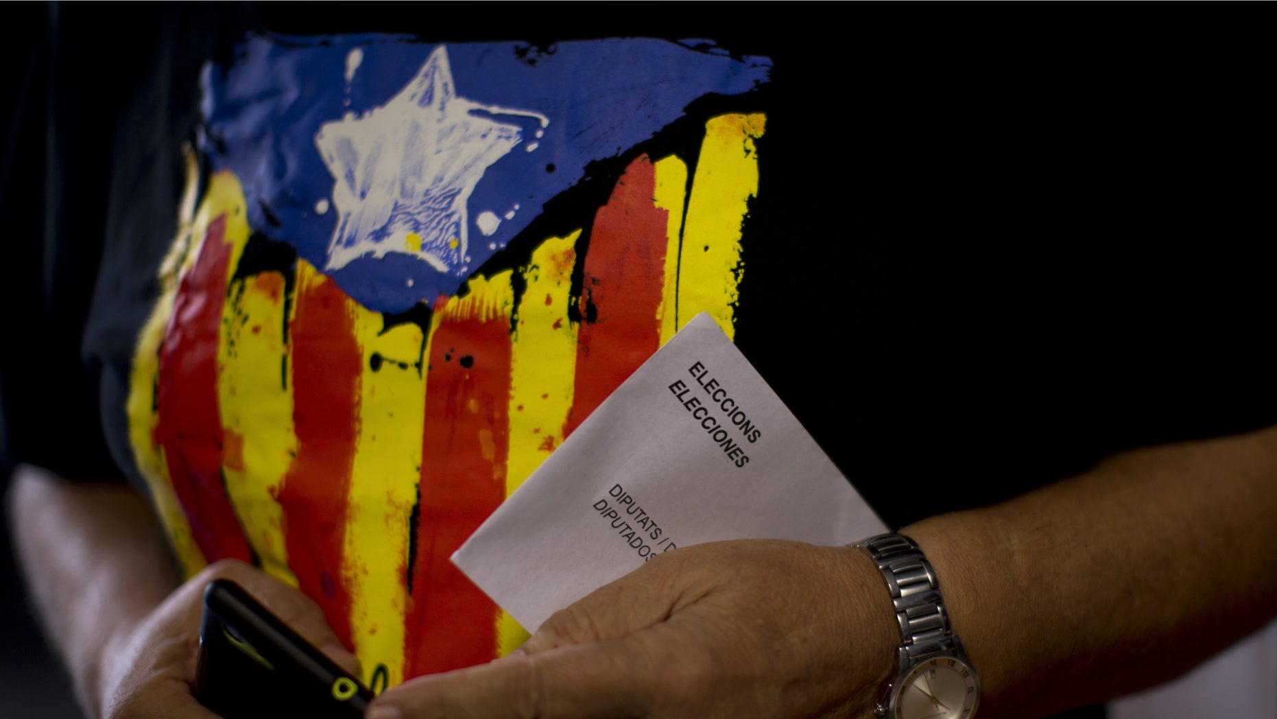 A man holds his ballot paper before voting at a polling station in Barcelona, Spain, Sunday Sept. 27, 2015. Voters in Catalonia go to the polls on Sunday to elect regional lawmakers, with pro-secession parties saying they will push for independence within 18 months if they win a majority in the 165-seat parliament, as most opinion polls predict they will. (AP Photo/Emilio Morenatti)