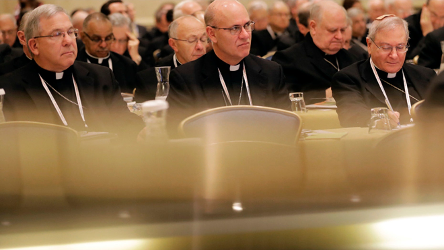 Members of the United States Conference of Catholic Bishops are seen above reflections on a piano as they attend the USCCB's annual fall meeting in Baltimore, Monday, Nov. 14, 2016. The bishops opened their meeting by urging President-elect Donald Trump to adopt humane policies toward immigrants and refugees. (AP Photo/Patrick Semansky)