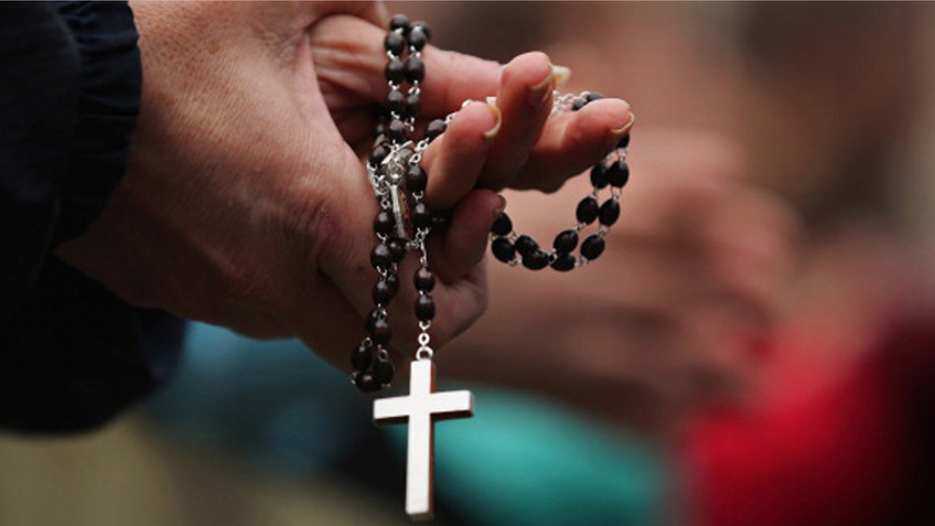 VATICAN CITY, VATICAN - MARCH 13: A woman holds rosary beads while she prays and waits for smoke to emanate from the chimney on the roof of the Sistine Chapel which will indicate whether or not the College of Cardinals have elected a new Pope on March 13, 2013 in Vatican City, Vatican. Pope Benedict XVI's successor is being chosen by the College of Cardinals in Conclave in the Sistine Chapel. The 115 cardinal-electors, meeting in strict secrecy, will need to reach a two-thirds-plus-one vote majority to elect the 266th Pontiff. (Photo by Dan Kitwood/Getty Images)
