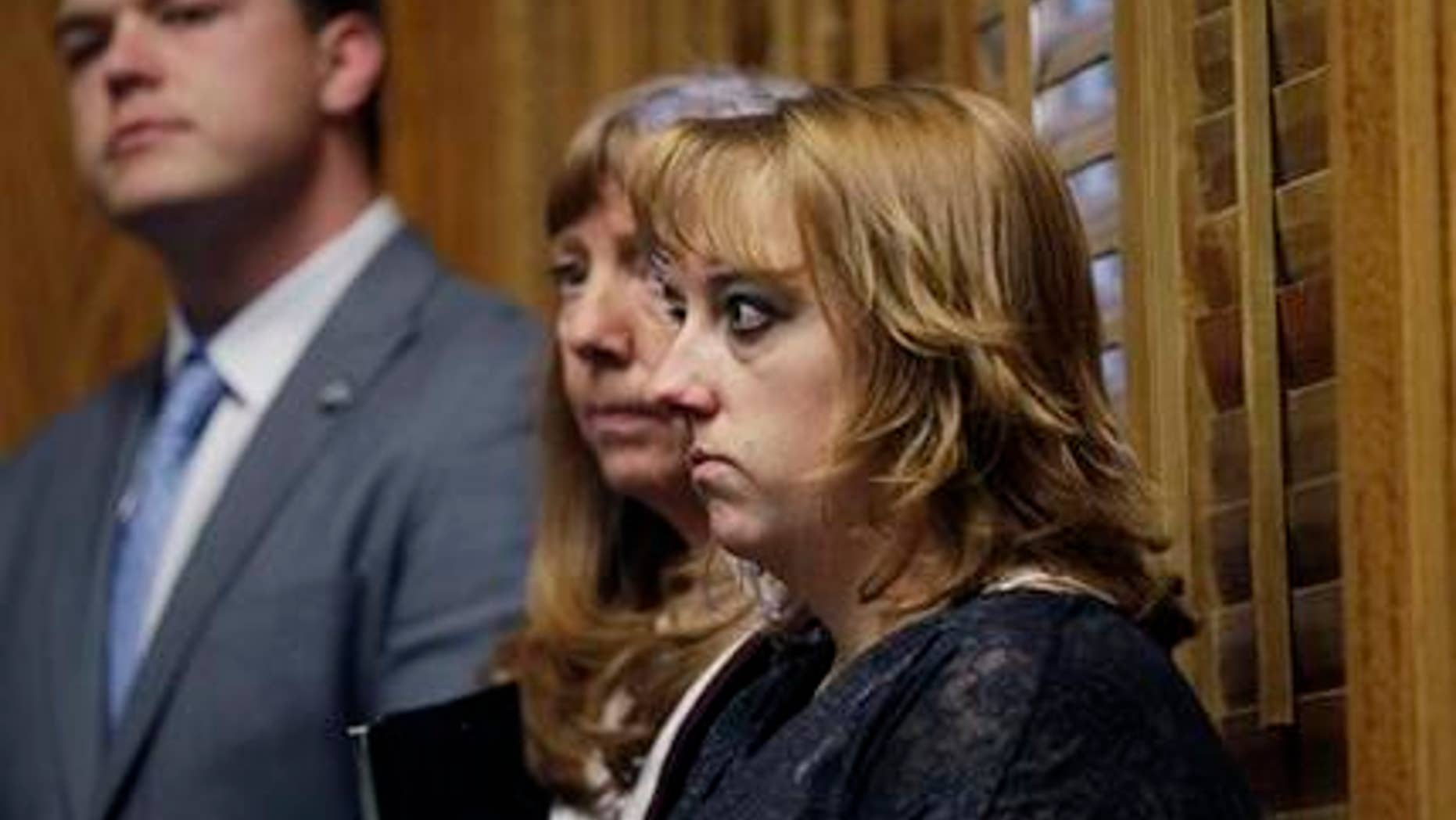 In this Monday, Jan. 28, 2013 photo, Heather Surovik, who lost her 8 1/2-month-old unborn son when her car was struck by drunken driver Gary Sheats in 2012, prepares to speak at a news conference promoting a political drive to grant personhood status to unborn fetuses at the Colorado State Capitol in Denver. Prosecutors could not file vehicular manslaughter charges because her unborn son was not legally a person. When a Catholic hospital in Colorado used the same argument to avoid a wrongful death lawsuit over twin fetuses that died in its care, it triggered an avalanche of criticism. At center is Surovik's mother, Terry Koester, and at left is Keith Mason of the organization Personhood USA. (AP Photo/Brennan Linsley)