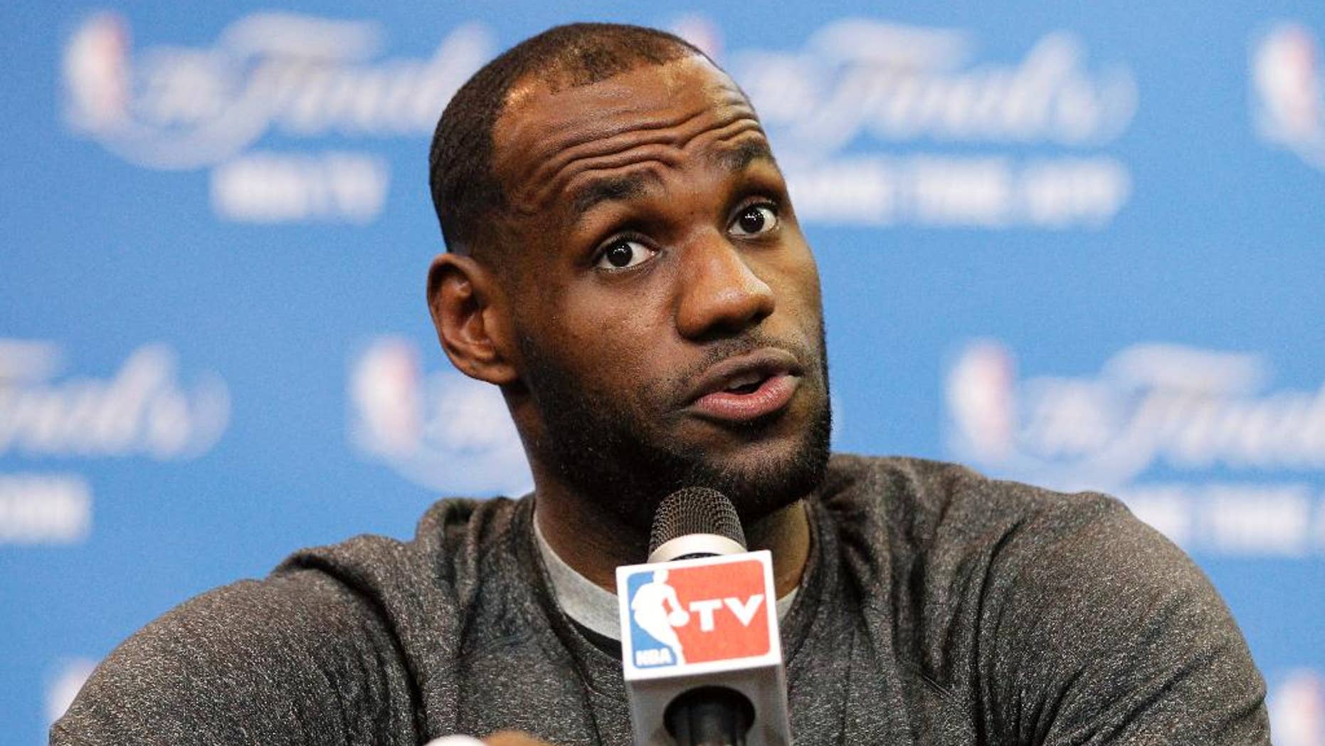 FILE - In this June 14, 2014 file photo, Miami Heat forward LeBron James responds to a question during a media availability for the NBA basketball finals in San Antonio. A person familiar with the deals says the Cavaliers have agreed to trade guard Jarrett Jack, swingman Sergey Karasev and center Tyler Zeller, moves that can help their pursuit of LeBron James by clearing salary cap space. The Cavs have agreements with the Brooklyn Nets and Boston Celtics, according to the person who spoke Wednesday, July 9, 2014, to The Associated Press. The person spoke on condition of anonymity because teams are not permitted to discuss any trades until the league's moratorium ends Thursday. (AP Photo/Tony Gutierrez)