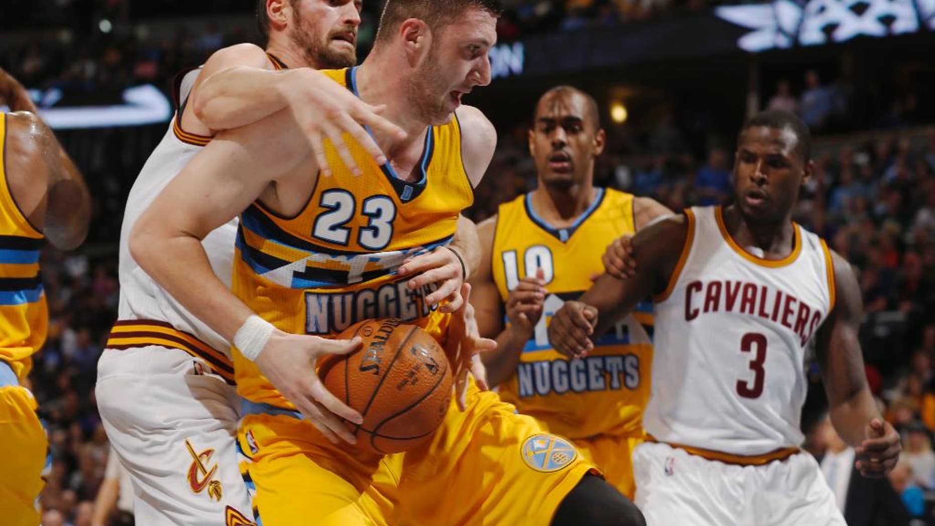Cleveland Cavaliers forward Kevin Love, front left, fouls Denver Nuggets center Jusuf Nurkic, front right, of Bosnia Herzegovina, as Nuggets guard Arron Afflalo, back left, and Cavaliers guard Dion Waiters look on in the fourth quarter of the Cavaliers' 110-101 victory in an NBA basketball game in Denver on Friday, Nov. 7, 2014. (AP Photo/David Zalubowski)