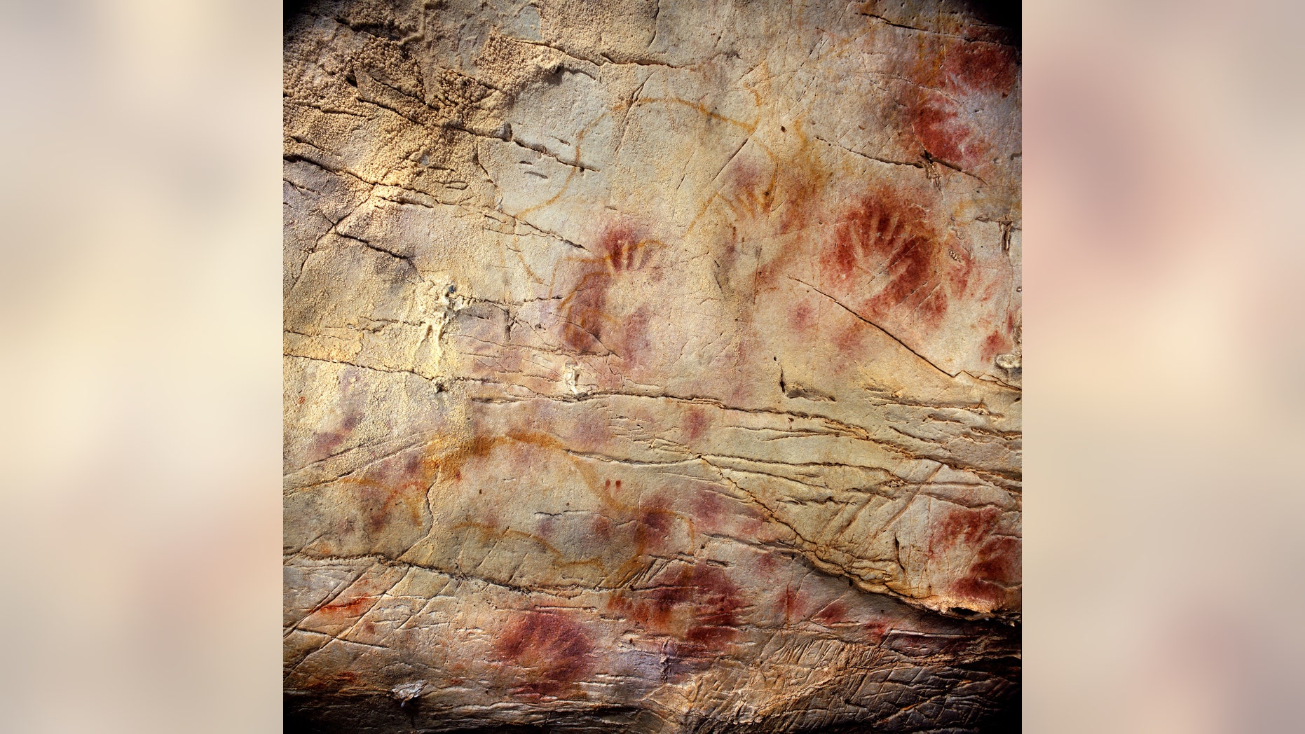 This undated photo shows detail of the Panel of Hands, El Castillo Cave showing red disks and hand stencils made by blowing or spitting paint onto the wall.