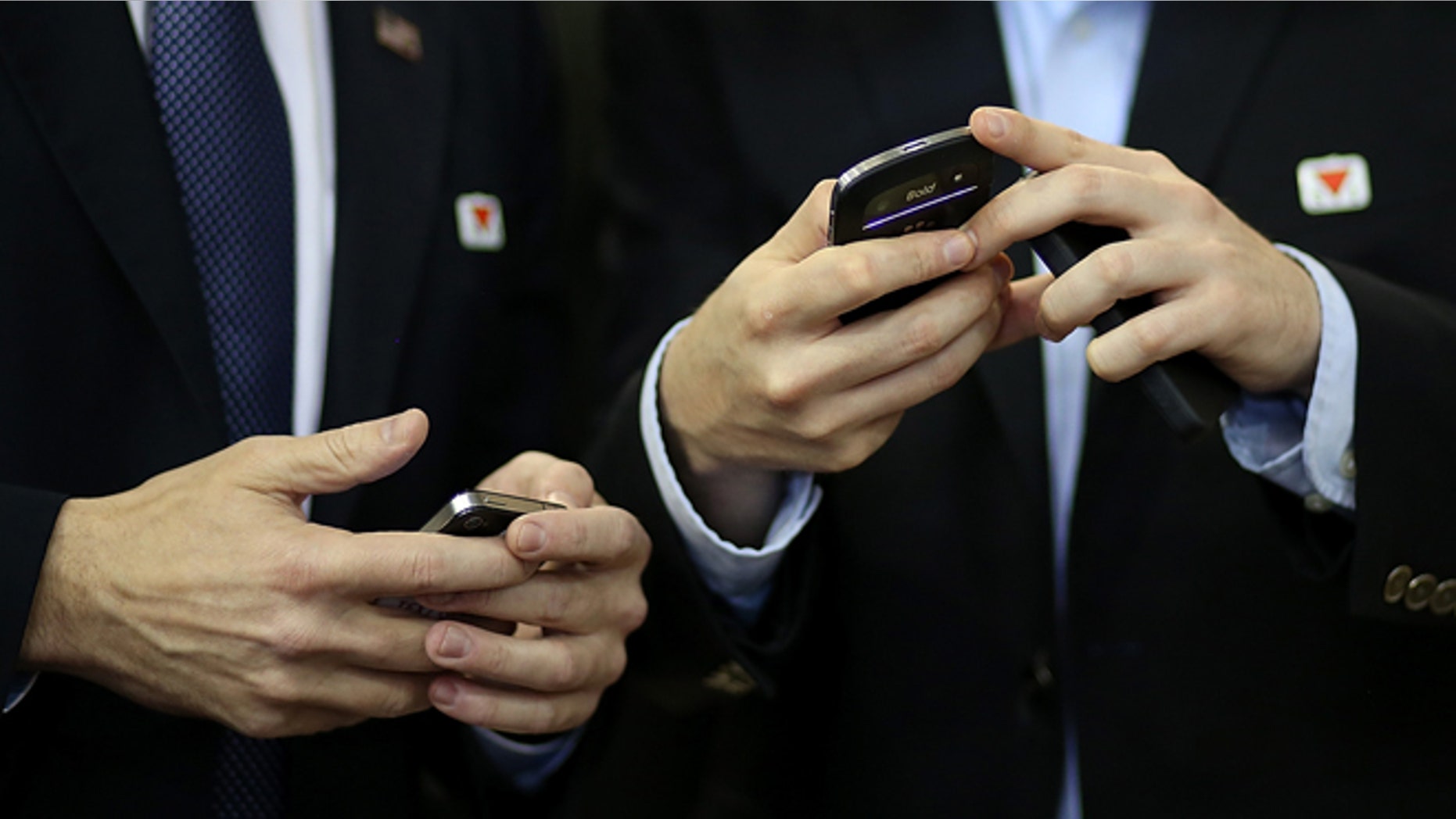 AVON LAKE, OH - OCTOBER 29: Campaign staffers for Republican presidential candidate, former Massachusetts Gov. Mitt Romney check their smartphones during a campaign rally at Avon Lake High School on October 29, 2012 in Avon Lake, Ohio. Romney canceled campaign events on October 29 and 30 due to Hurricane Sandy. (Photo by Justin Sullivan/Getty Images)
