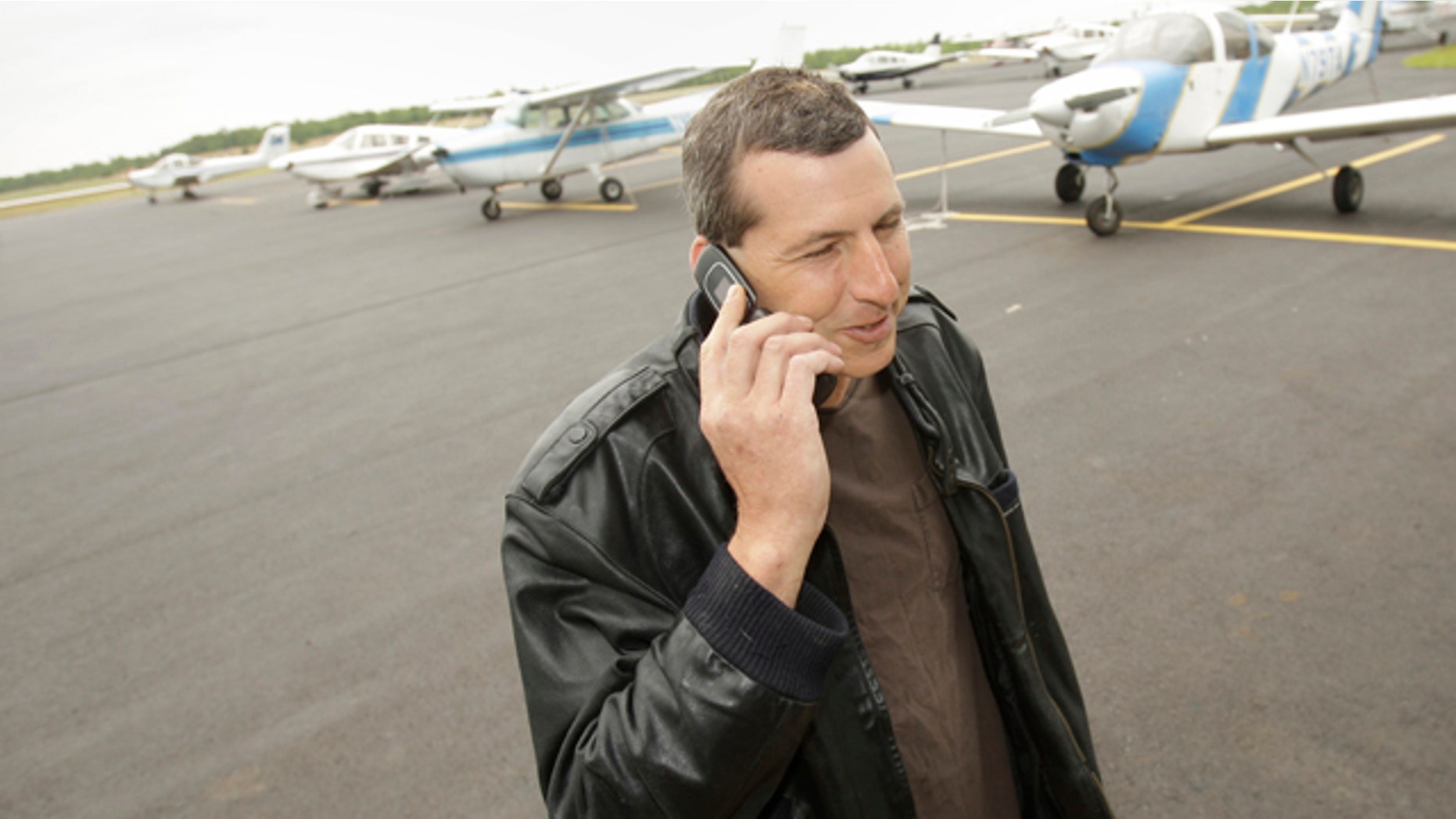 April 20, 2011: Commercial pilot Bill Phillips uses his cellphone on the tarmac at North Little Rock municipal Airport in North Little Rock, Ark.