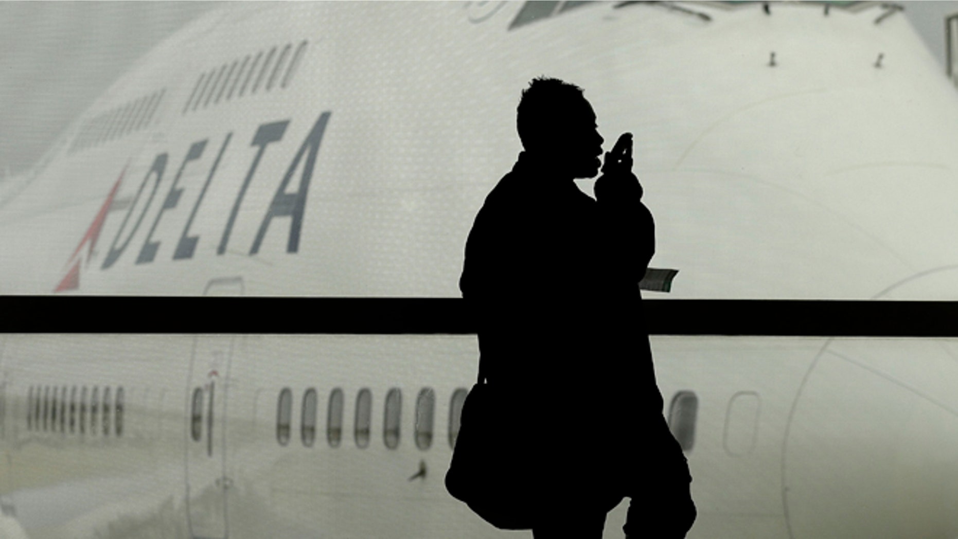 A traveler on Delta Airlines waits for her flight in Detroit. As federal regulators consider removing a decades-old prohibition on making phone calls on planes, a majority of air travelers oppose such a change, a recent poll found.