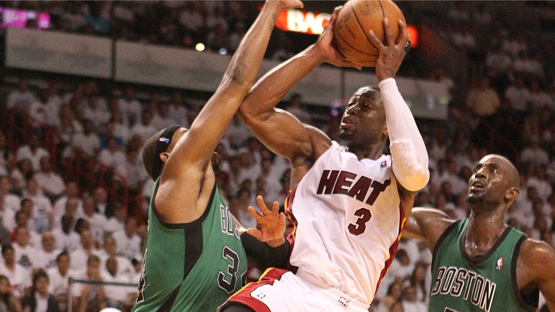 Dwyane Wade goes to the basket against Paul Pierce,left and Kevin Garnett,right during the fourth quarter of game 1 of the NBA Eastern Conference Finals between the Boston Celtics against Miami Heat at the AmericanAirlines Arena in Miami on Monday, May 28, 2012. The Heat beat the Boston Celtics 93-79. (AP Photo/El Nuevo Herald, David David Santiago )