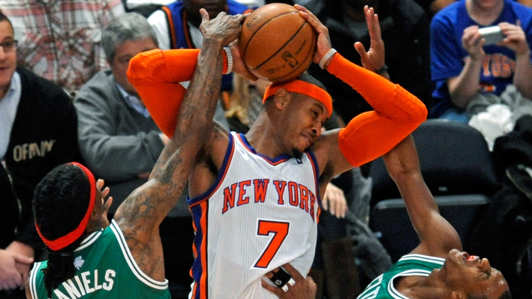 New York Knicks' Carmelo Anthony (7) fouls Boston Celtics' Rajon Rondo, right, with his elbow as he is pressured by Celtics' Marquis Daniels (4) during the third quarter of an NBA basketball game Sunday, Dec. 25, 2011 at Madison Square Garden in New York. Knicks won 106-104. (AP Photo/Bill Kostroun)