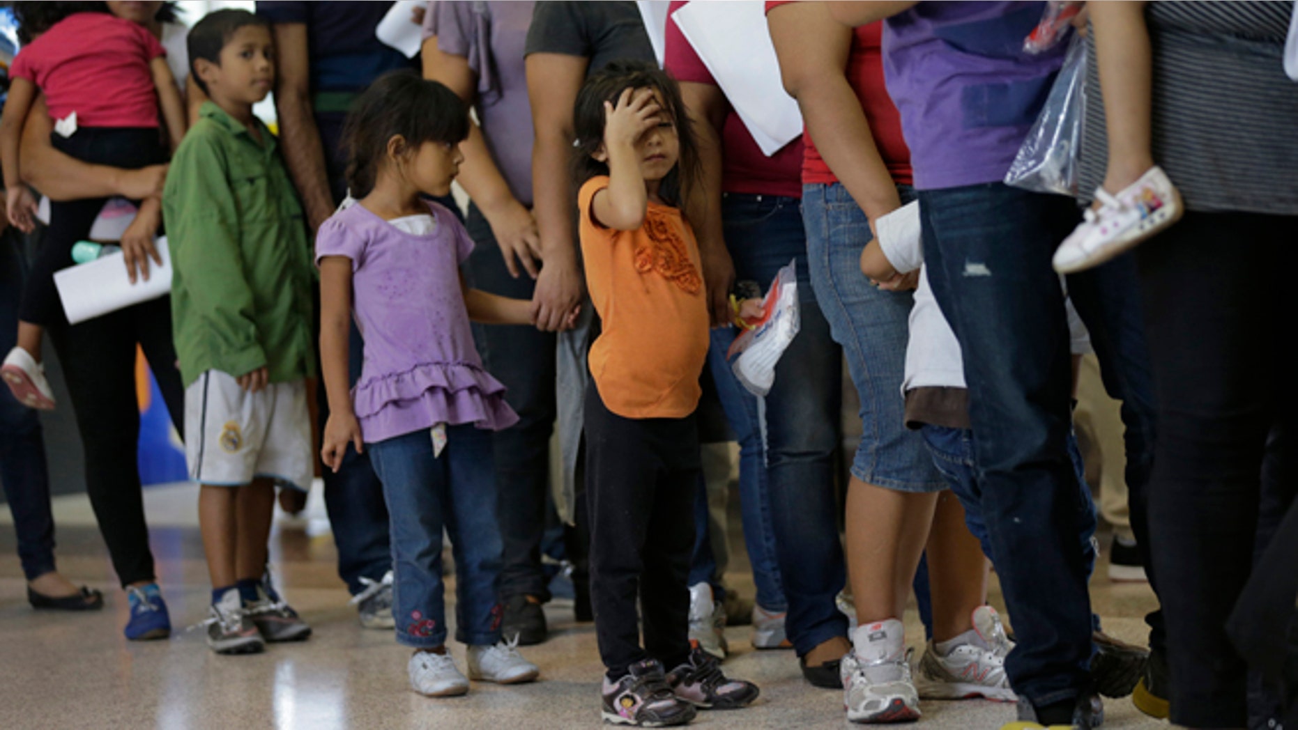 FILE - In this June 20, 2014, file photo, immigrants who entered the U.S. illegally stand in line for tickets at the bus station after they were released from a U.S. Customs and Border Protection processing facility in McAllen, Texas. Hundreds of families and children from Central America caught traveling alone in recent weeks across the Mexican border told U.S. immigration agents they made the dangerous journey in part because they believe they will be permitted to stay in the United States and collect public benefits, according to internal intelligence files from the Homeland Security Department. (AP Photo/Eric Gay, File)