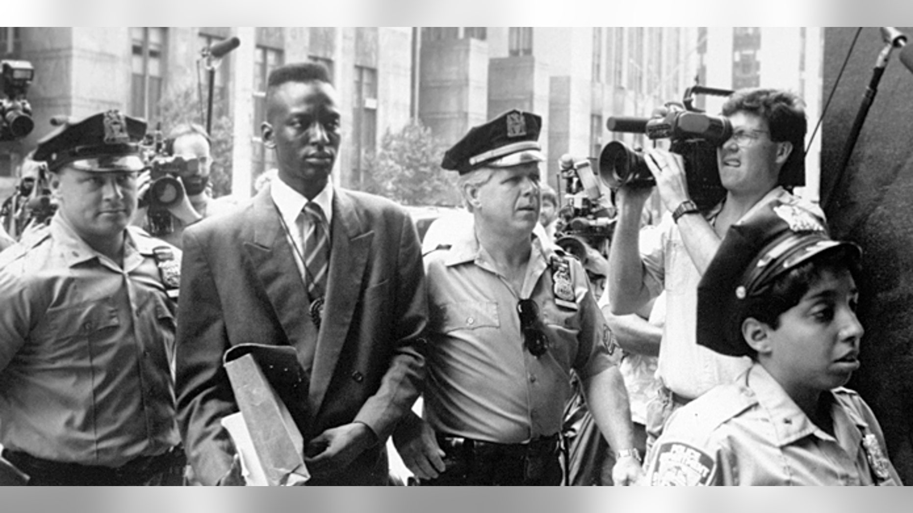 FILE - This 1990 file photo provided by Sundance Selects shows accused rapist Yusef Salaam, second right, being escorted by police in New York in 1990. Salaam is the subject of the documentary, "The Central Park Five," about the 1989 case of five black and Latino teenagers who were convicted of raping a white woman in Central Park. A city official said Friday, June 20, 2014 that New York City has agreed to a $40 million settlement in a civil rights lawsuit filed against police and prosecutors by Salaam and four co-defendants exonerated in the notorious case of a jogger attacked in Central Park in 1989. (AP Photo/Sundance Selects, NY Daily News, File)
