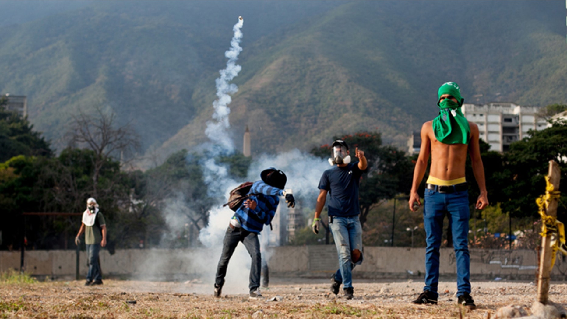 A demonstrator throws back a teargas canister towards police lines, during clashes in an anti-government protest in Caracas, Venezuela, Monday, March 10, 2014. The Venezuelan government and opposition appear to have reached a stalemate, in which street protests continue almost daily while the opposition sits out a peace process it calls farcical. (AP Photo/Alejandro Cegarra)
