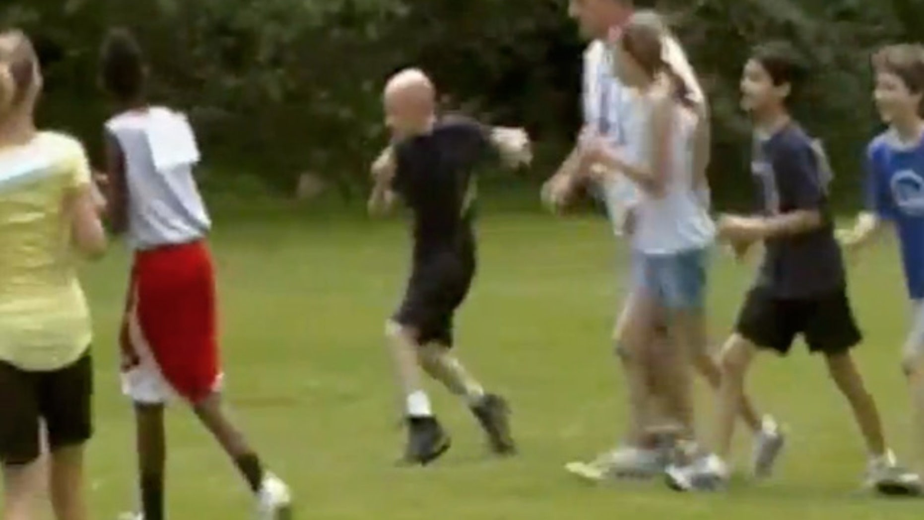 June 2, 2012: This image made from a video posted on YouTube on May 27, 2012, 11-year-old Matt Woodrum, third from left, is joined by physical education teacher John Blaine, fourth from left, and other students during a 400-meter race at Colonial Hills Elementary School in Worthington, Ohio.