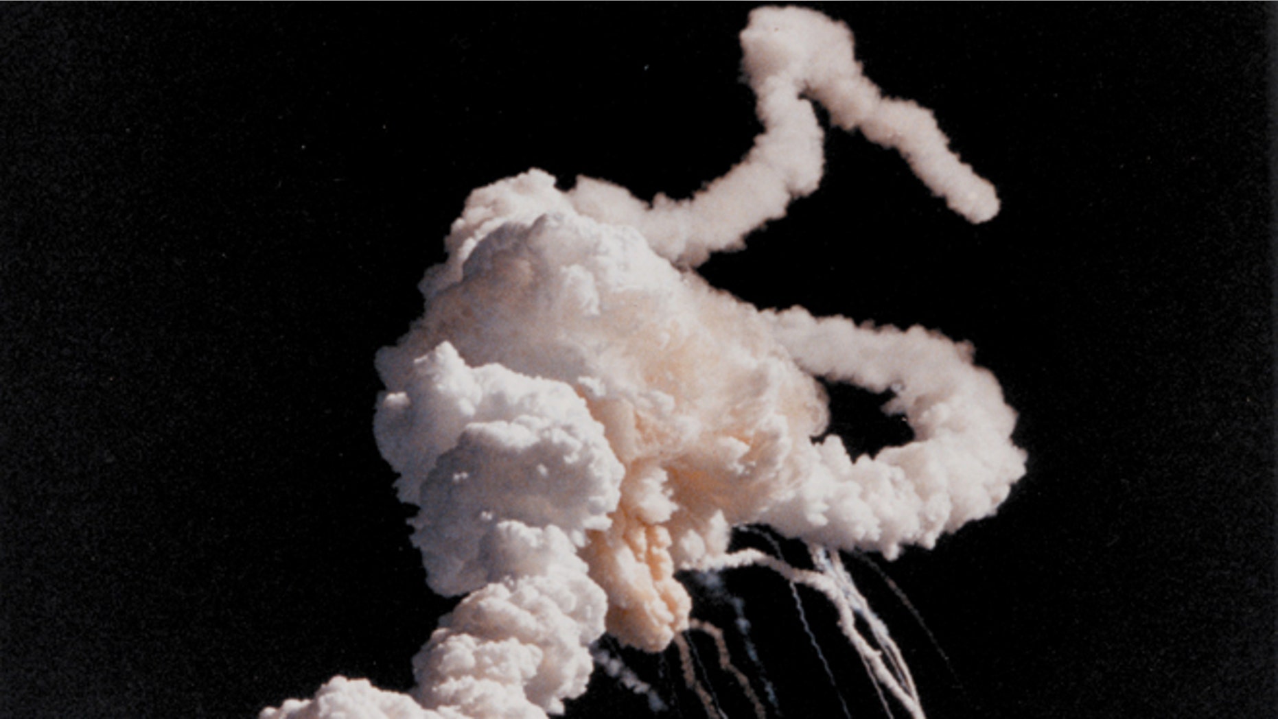Jan. 28, 1986: The Space Shuttle Challenger and her seven-member crew were lost when a ruptured O-ring in the right solid rocket booster caused an explosion soon after launch. This photograph, taken a few seconds after the accident, shows the main engines and solid rocket booster exhaust plumes entwined around a ball of gas from the external tank.