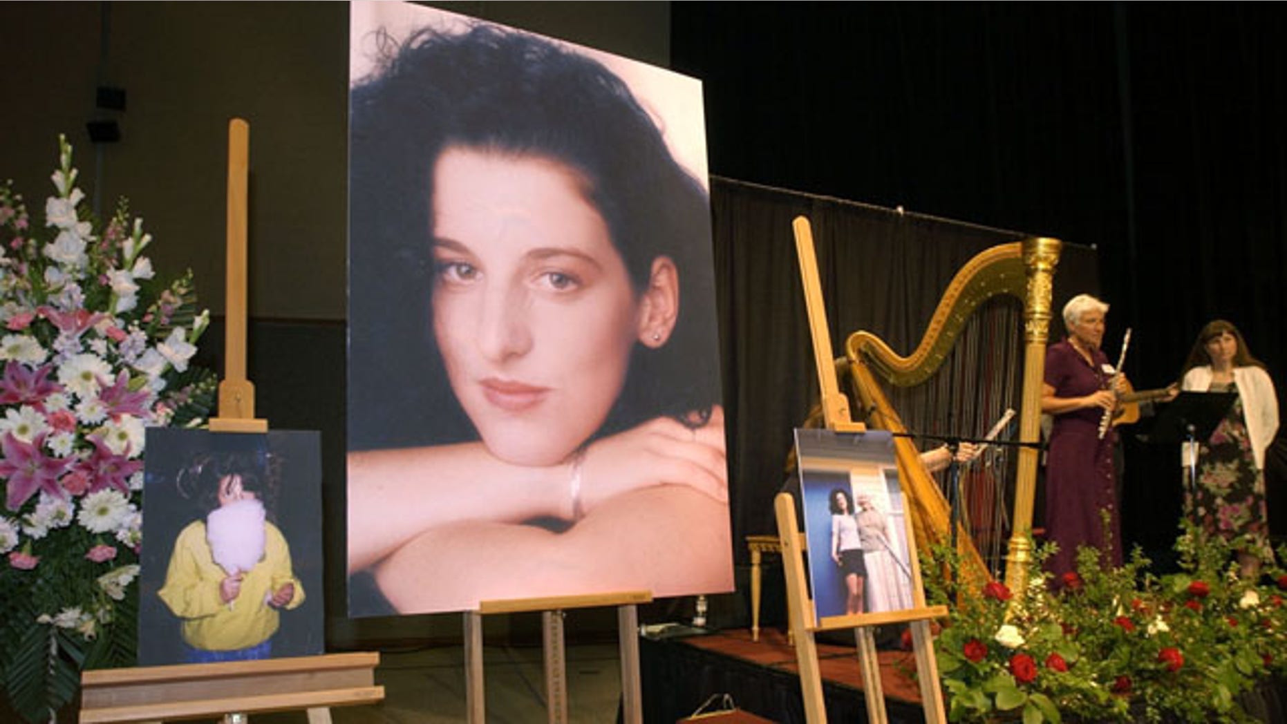 May 28, 2002: Photographs of Chandra Levy are on display as musicians, right, stand by at the memorial service for Levy at the Modesto Centre Plaza in Modesto, Calif. More than nine years after the Washington, D.C., intern's disappearance became a mystery that garnered national attention, the murder trial returns after a six-day hiatus.