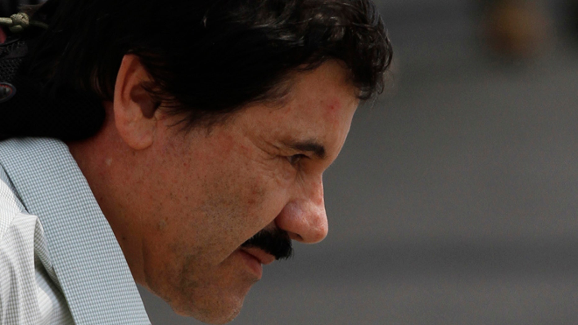 Joaquin "El Chapo" Guzman is escorted to a helicopter in handcuffs by Mexican navy marines at a navy hanger in Mexico City, Saturday, Feb. 22, 2014. A senior U.S. law enforcement official said Saturday, that Guzman, the head of Mexico's Sinaloa Cartel, was captured alive overnight in the beach resort town of Mazatlan. Guzman faces multiple federal drug trafficking indictments in the U.S. and is on the Drug Enforcement Administration's most-wanted list. (AP Photo/Marco Ugarte)