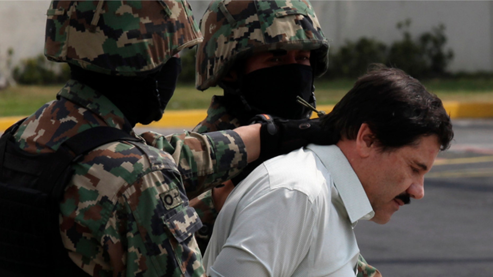 Joaquin "El Chapo" Guzman is escorted to a helicopter by Mexican navy marines in Mexico City, on Feb. 22, 2014.