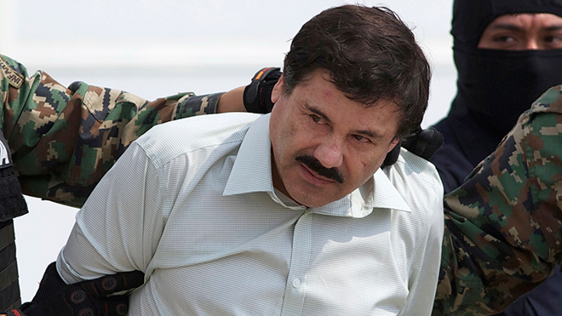 FILE - In this Feb. 22, 2014, file photo, Joaquin "El Chapo" Guzman, head of Mexicoâs Sinaloa Cartel, is escorted to a helicopter in Mexico City, following his capture overnight in the beach resort town of Mazatlan. Mexicoâs security commission said in a statement late Saturday, July 11, 2015, the top drug lord Joaquin âEl Chapoâ Guzman has escaped from a maximum security prison, the second time he has fled after being captured. (AP Photo/Eduardo Verdugo, File)