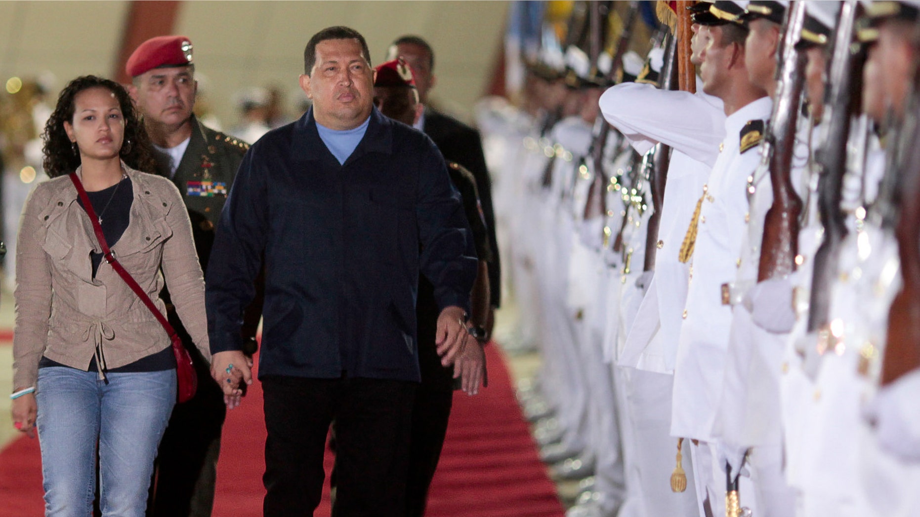 In this photo released by Miraflores Press Office, Venezuela's President Hugo Chávez, center, and his daughter Rosa Virginia, left, review the honor guard prior to their departure to Havana, at the Simón Bolívar airport in Maiquetía, Venezuela, Saturday. (AP Photo/Miraflores Press Office/Francisco Batista)