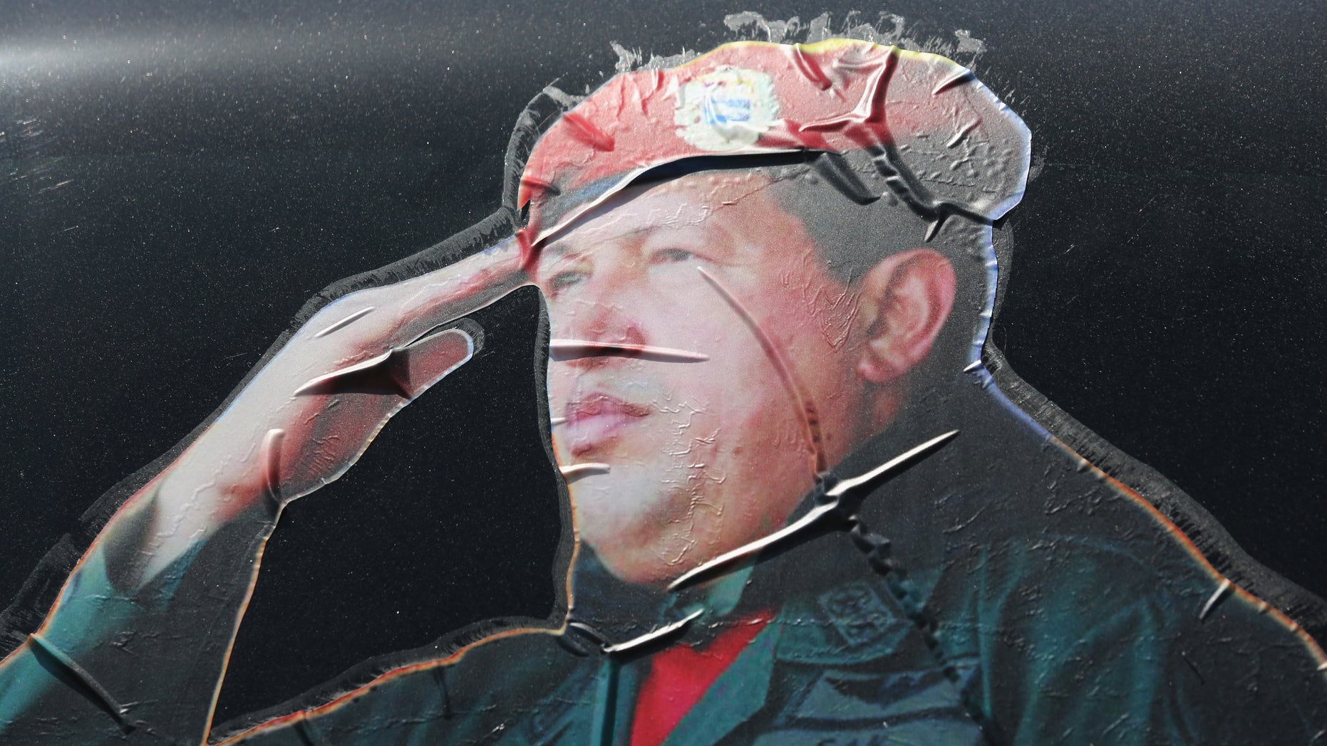 CARACAS, VENEZUELA - MARCH 04: A sticker on a car window honors former Venezuelan president Hugo Chavez near the military barracks where Chavez is entombed on March 4, 2014 in Caracas, Venezuela. Workers made last minute preparations for Wednesday's ceremony marking the first anniversary of Chavez' death on March 5, 2013. The anniversary has been marred by three weeks protests against the government of Chavez' chosen successor Nicolas Maduro. (Photo by John Moore/Getty Images)