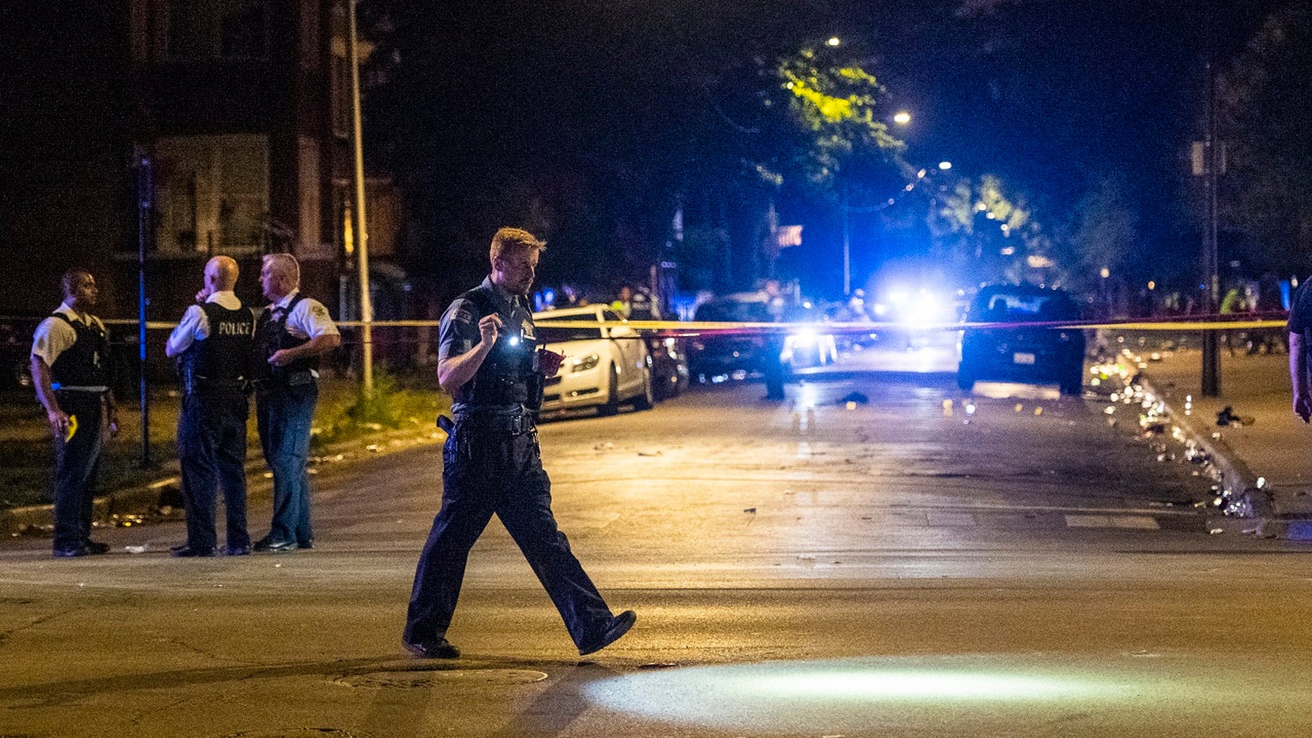 police investigate the scene where multiple people were shot in Chicago over the weekend.